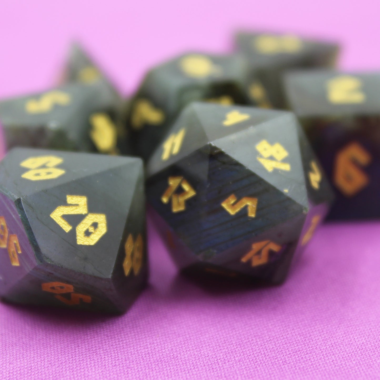 Closeup of Labradorite dice set on a purple cloth.