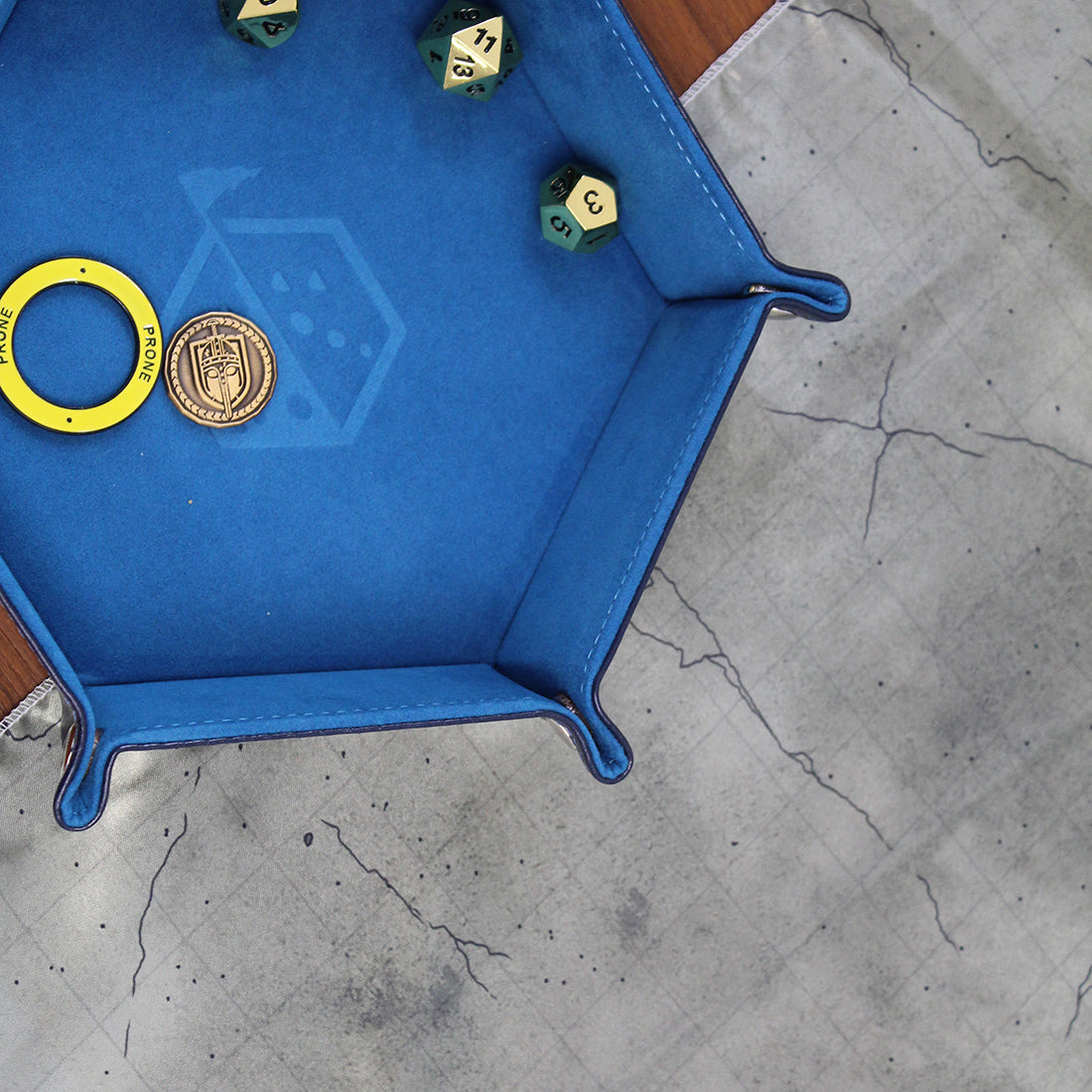 Close up photo of a cave floor battle map with a rolling tray containing dice sitting on it.