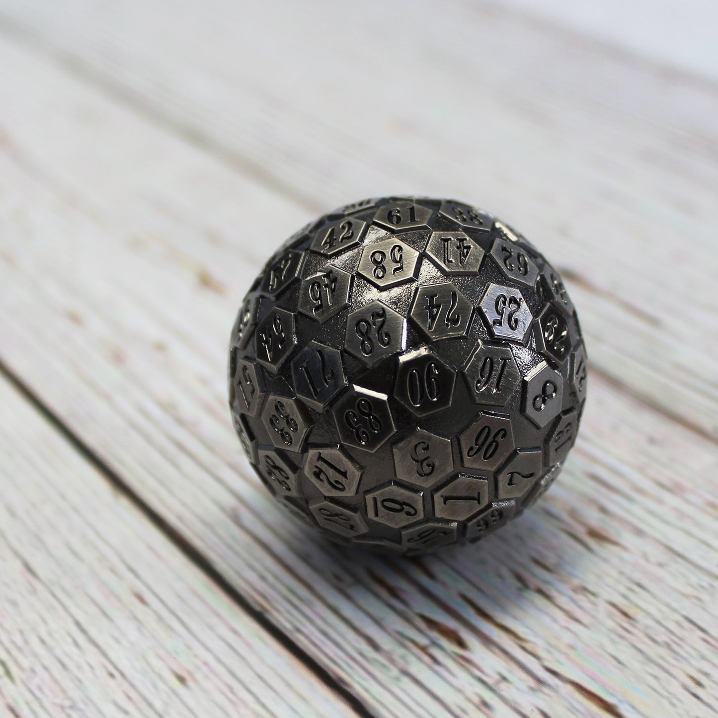 Metal D100 Antique Silver die on a light wooden surface