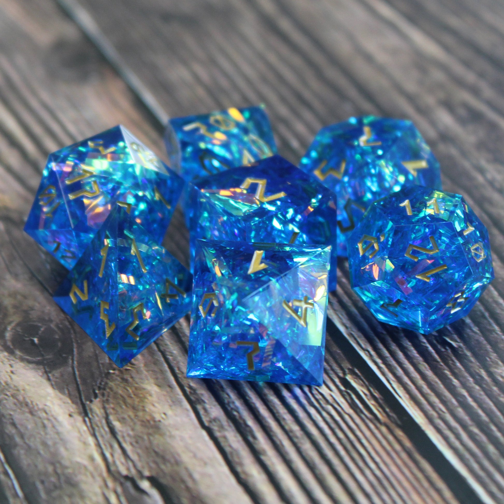 StarGlow Blue dice set arranged in a pile on a wood surface.
