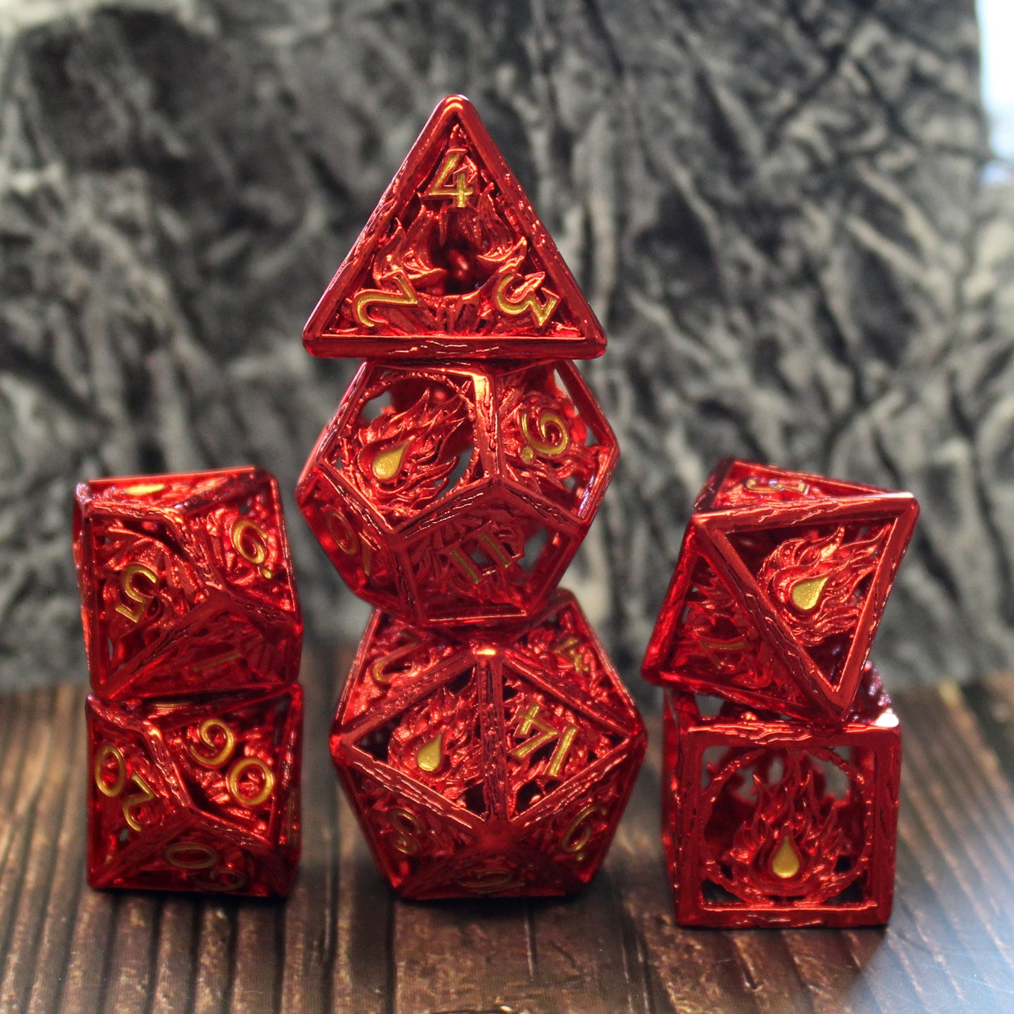 All 7 red dice piled up in 3 stacks. Two dice in first stack, three dice in second stack, two dice in third stack. All on a wood paneled surface with a black background.