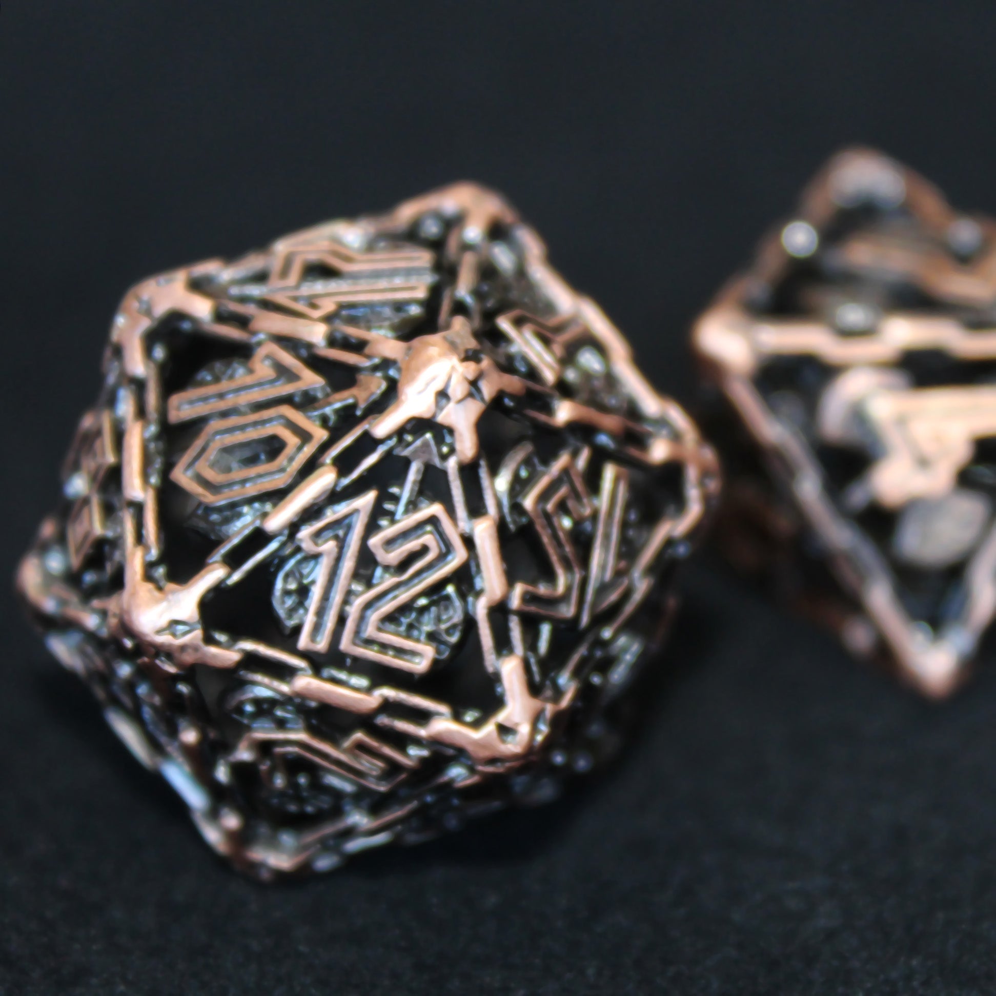 Close-up of the burnished copper Barbarian Cage Dice, featuring the hollow cage design without inking.