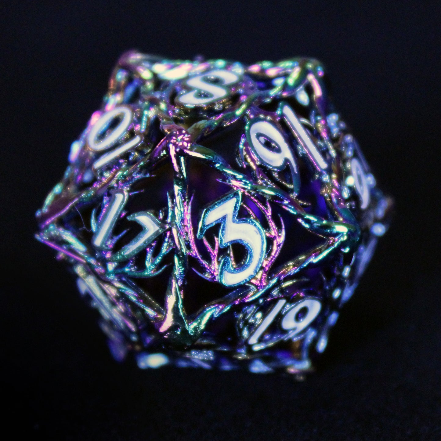 Close up of iridescent oil sheen Ranger die. Image showcases shiny caging and white number inking on a black background.