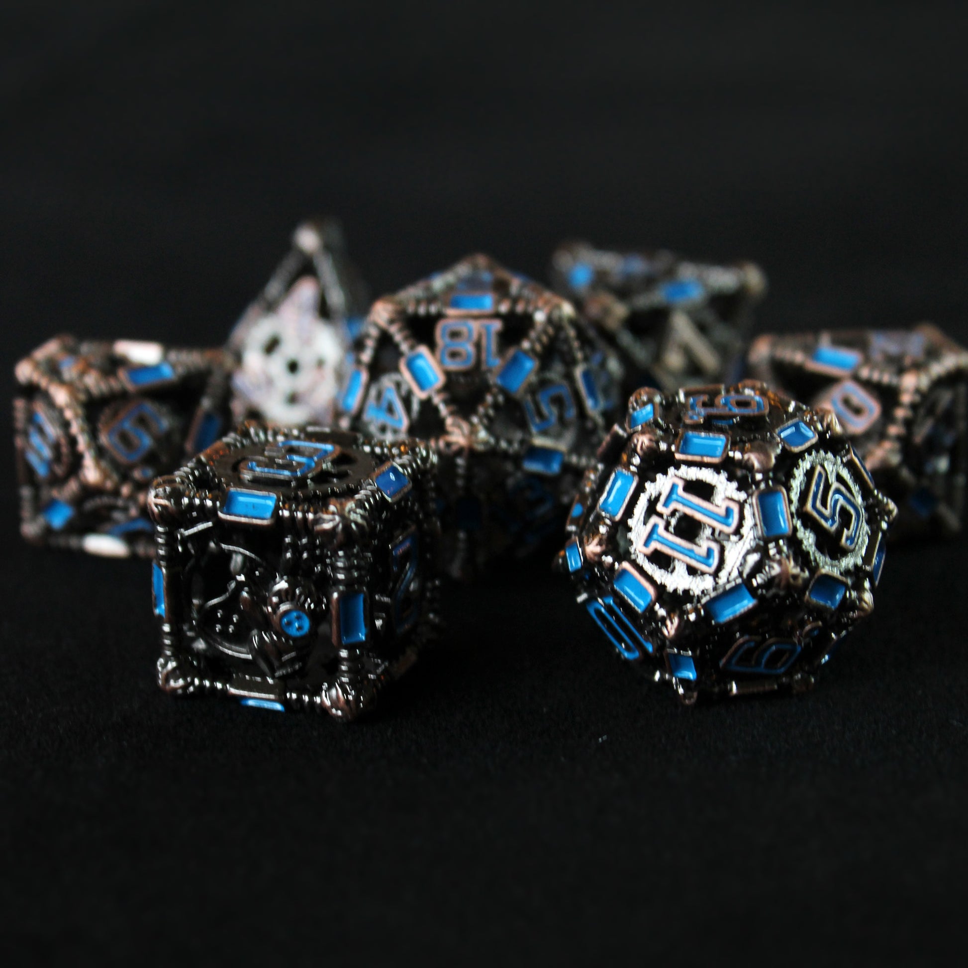 12 sided and 6 sided die in foreground, with other 5 blurred in background. All on  black background.