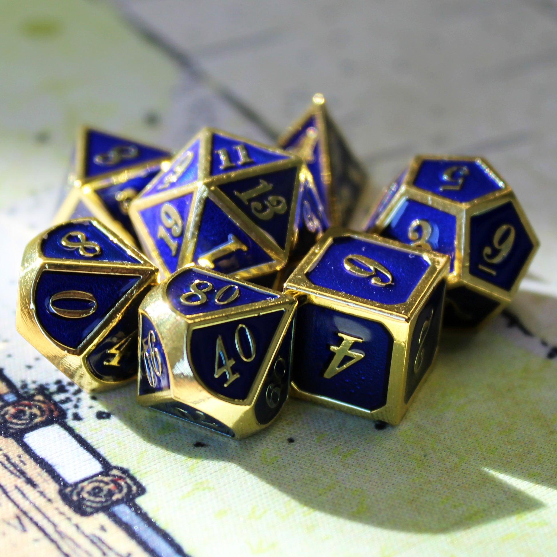Imperial blue and gold dice set scattered on a green play mat