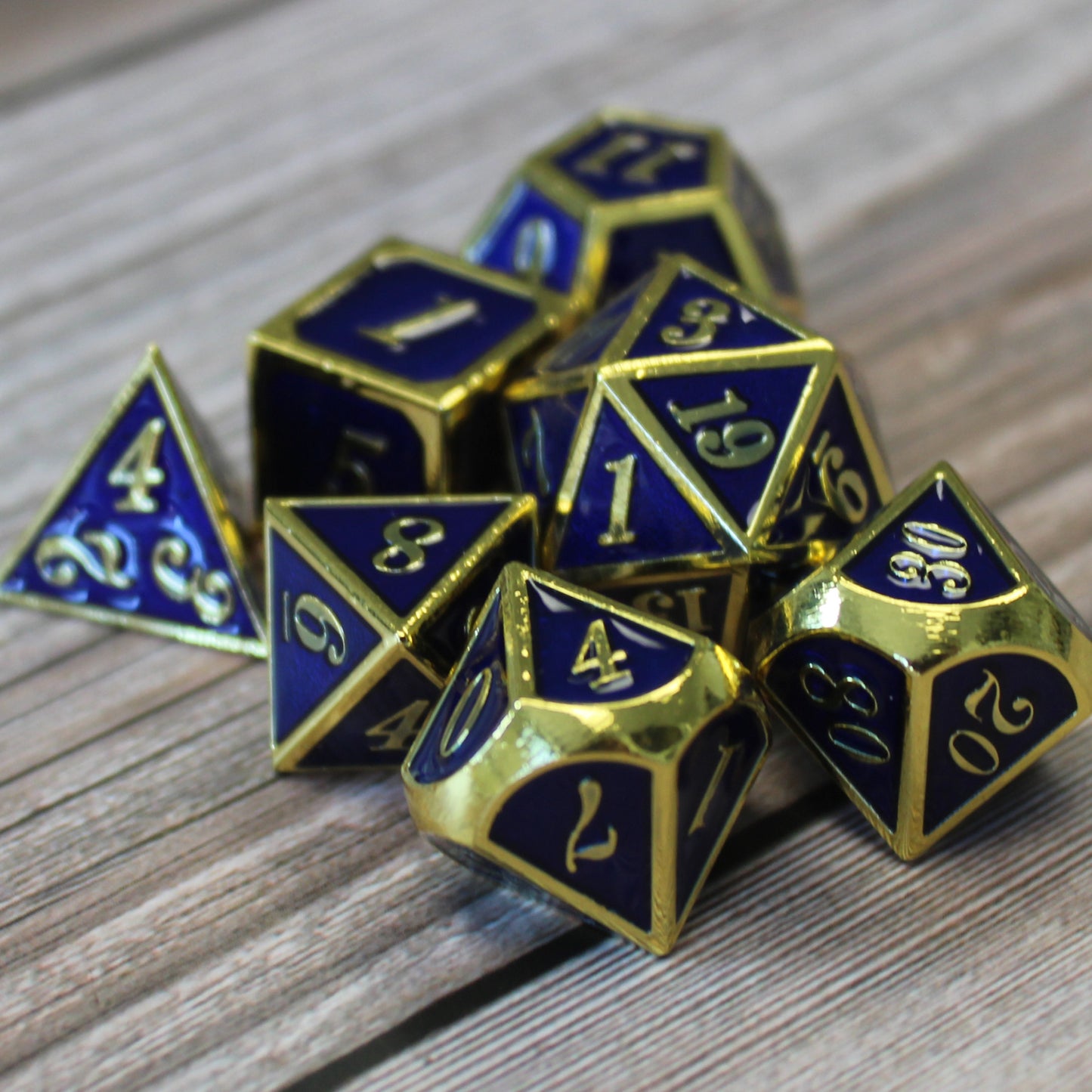 Imperial Blue and Gold dice set scattered on a wooden surface