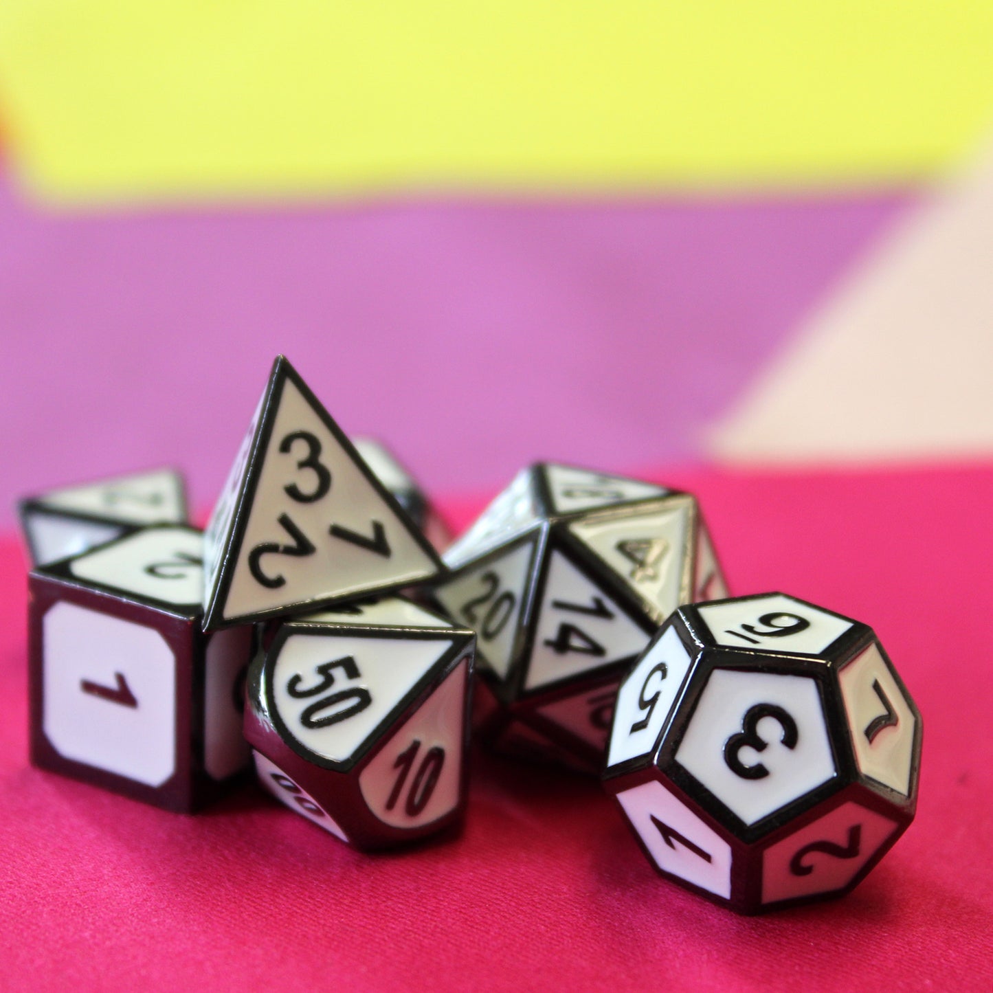 Imperial White dice set scattered on a pink fabric surface