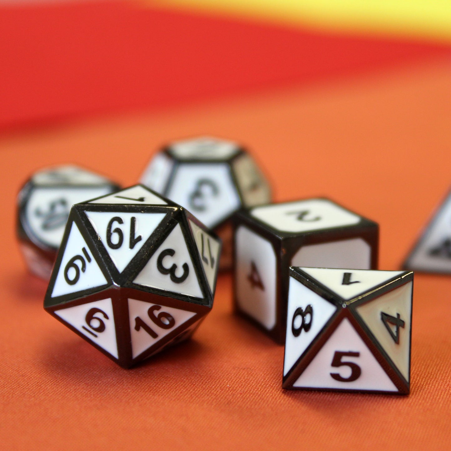 Imperial White dice set scattered on a orange fabric surface