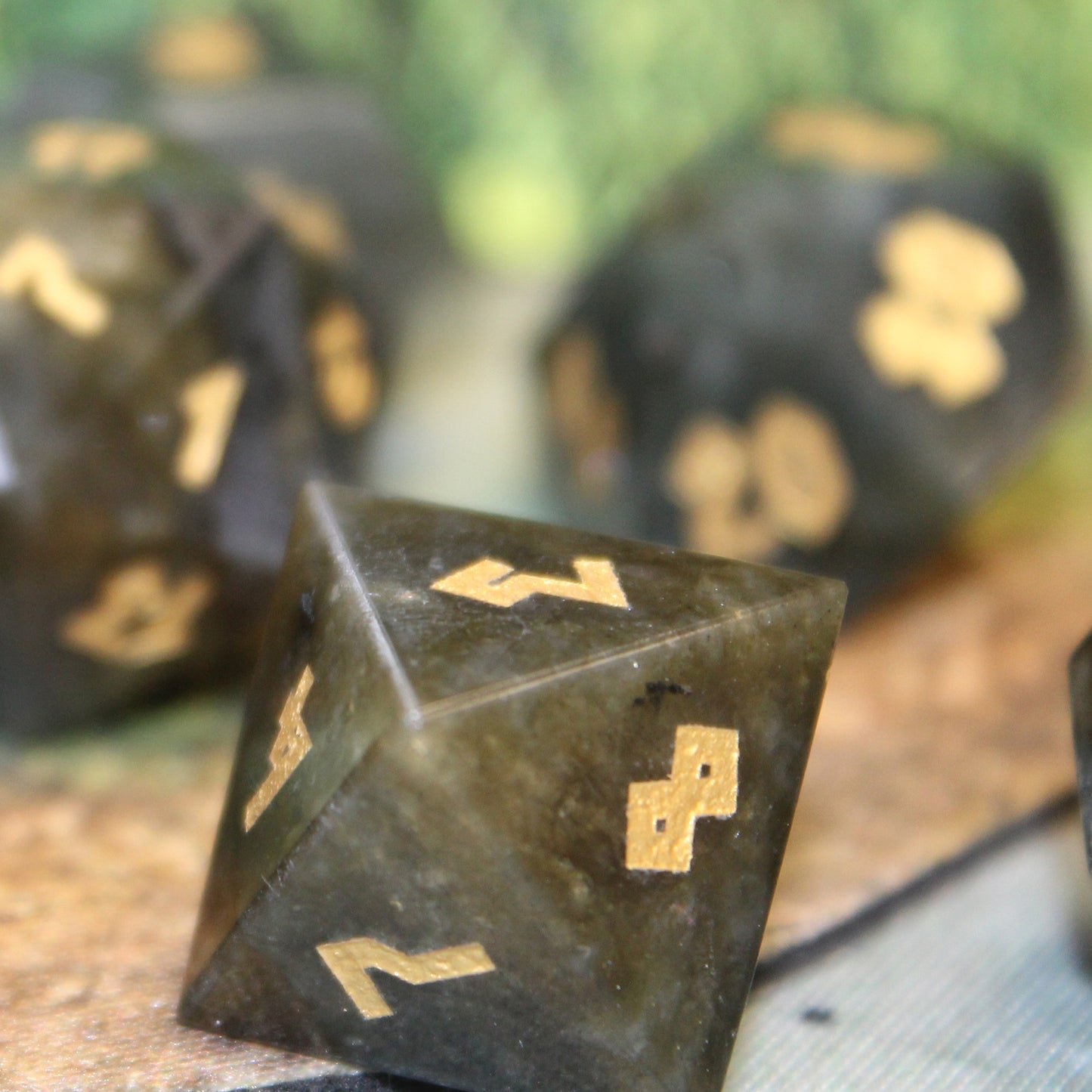 Closeup of D8 Labradorite die on a white, brown, and green game map.