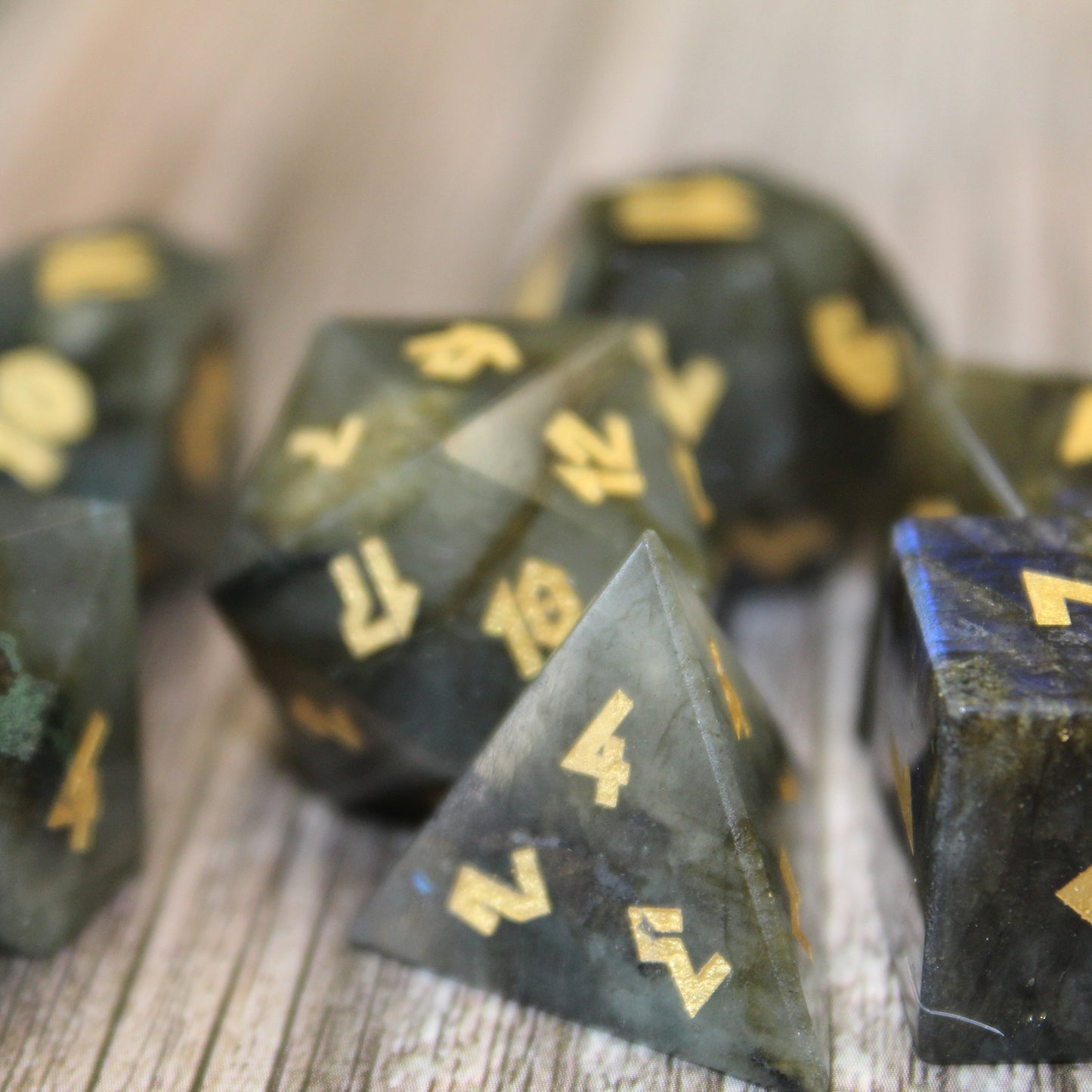 Closeup of Labradorite dice set on a wood surface.