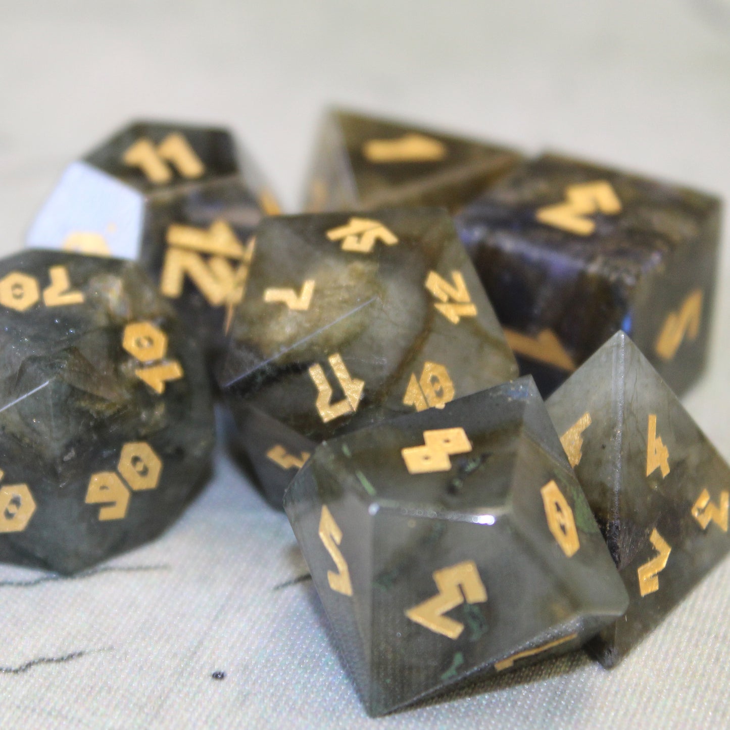 Closeup of Labradorite dice set on a white game map.