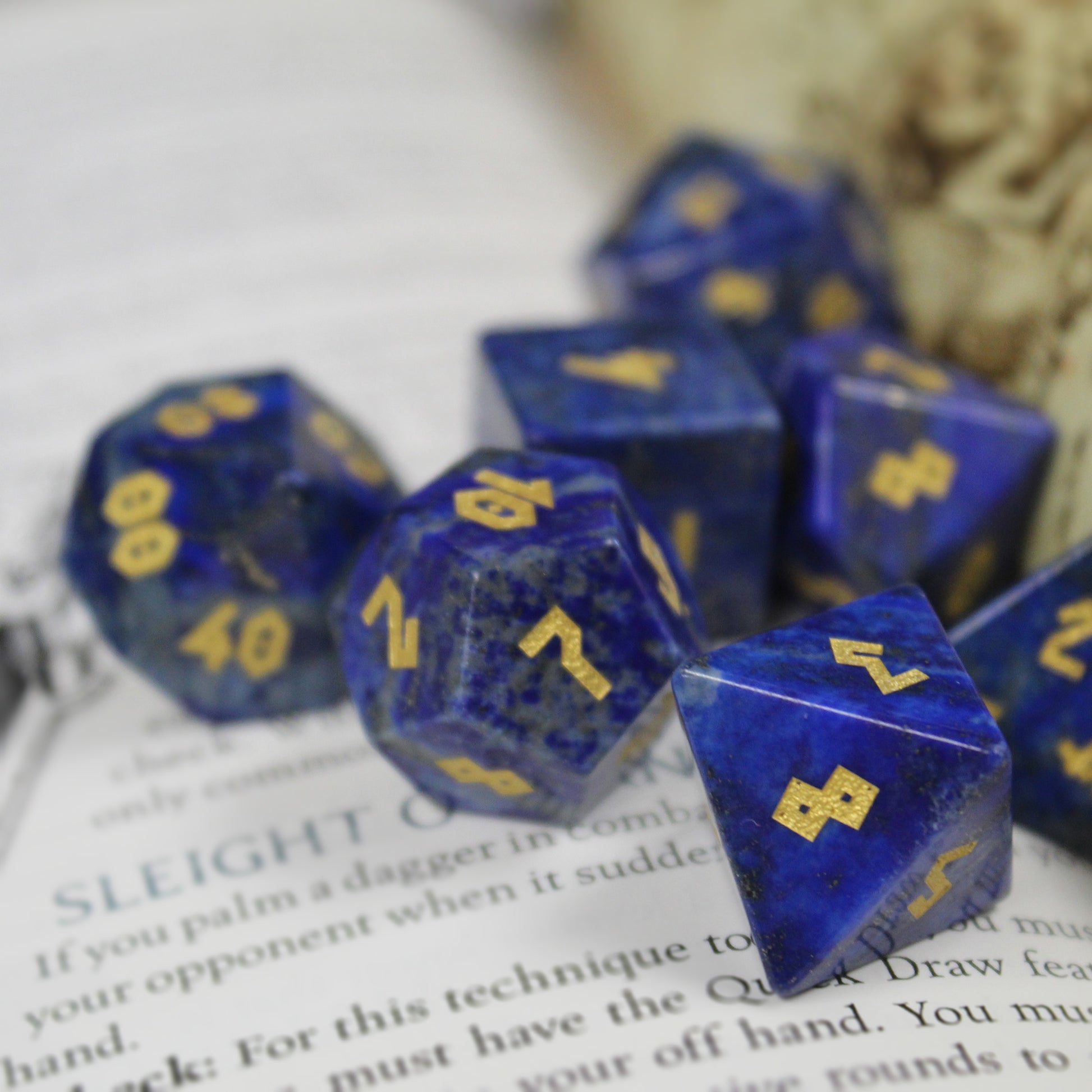 Lapis Lazuli dice set scattered on top of an open book