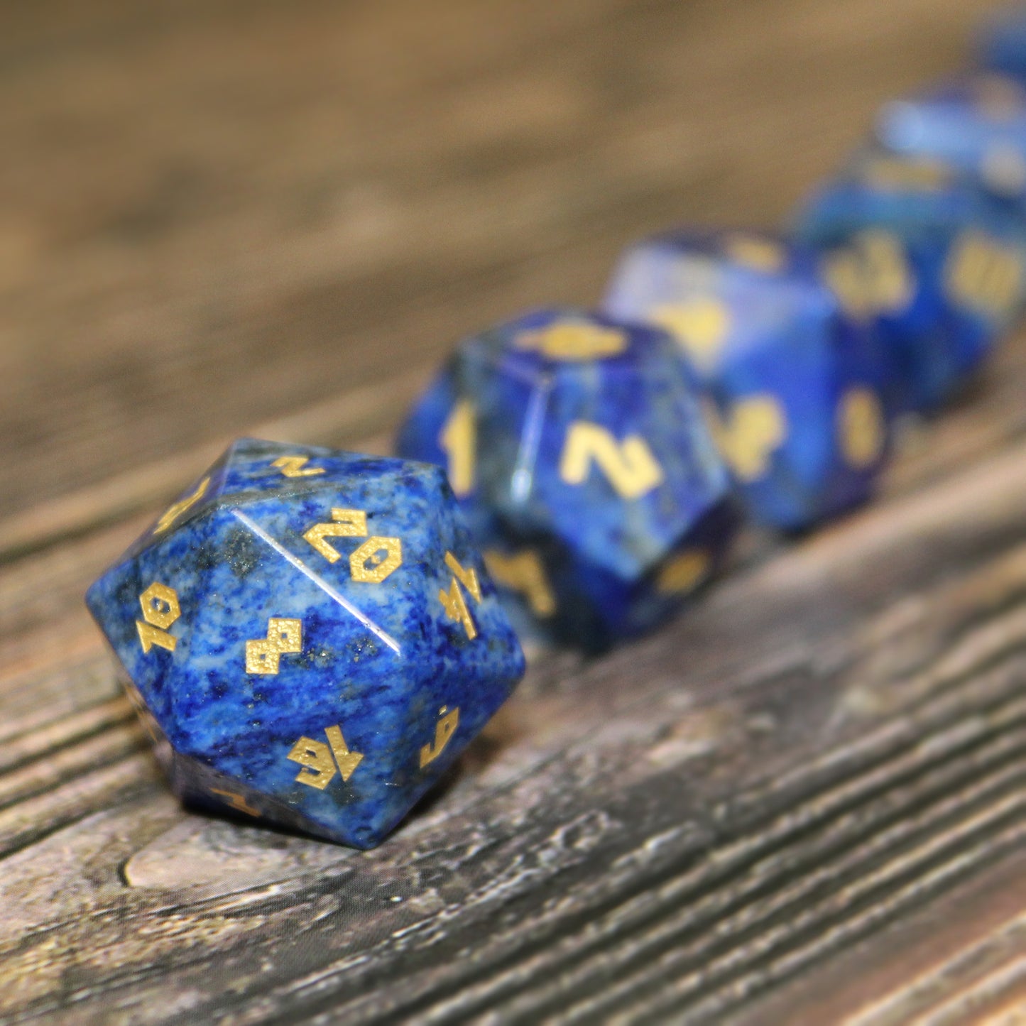Lapis Lazuli dice set arranged in a line on a wooden surface