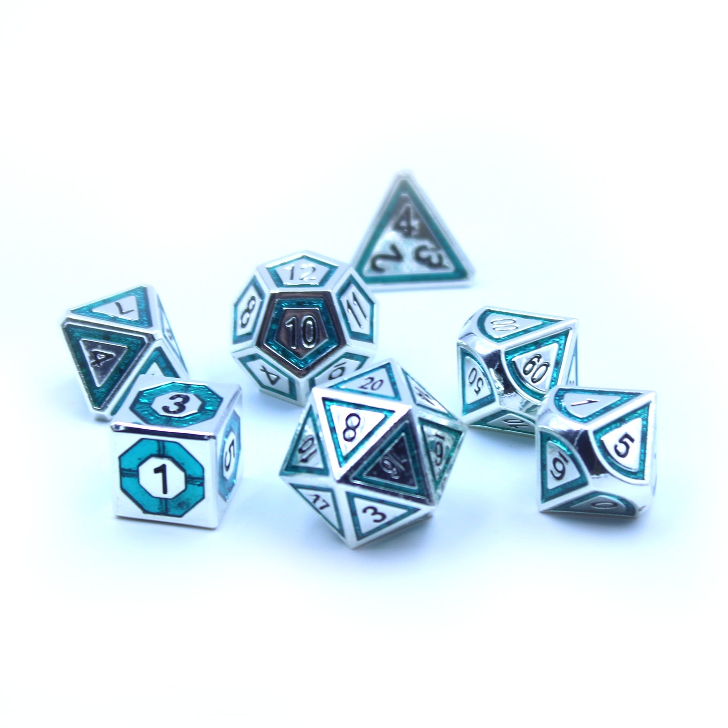 Photo of silver dice with bullseye-shaped teal inlays scattered on a white background.