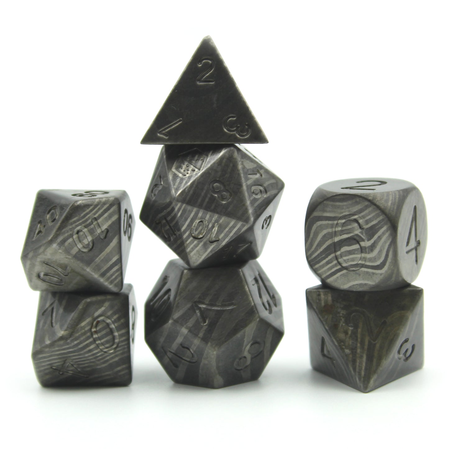 Metal Damascus Steel dice set arranged in 3 columns on a white surface and background.