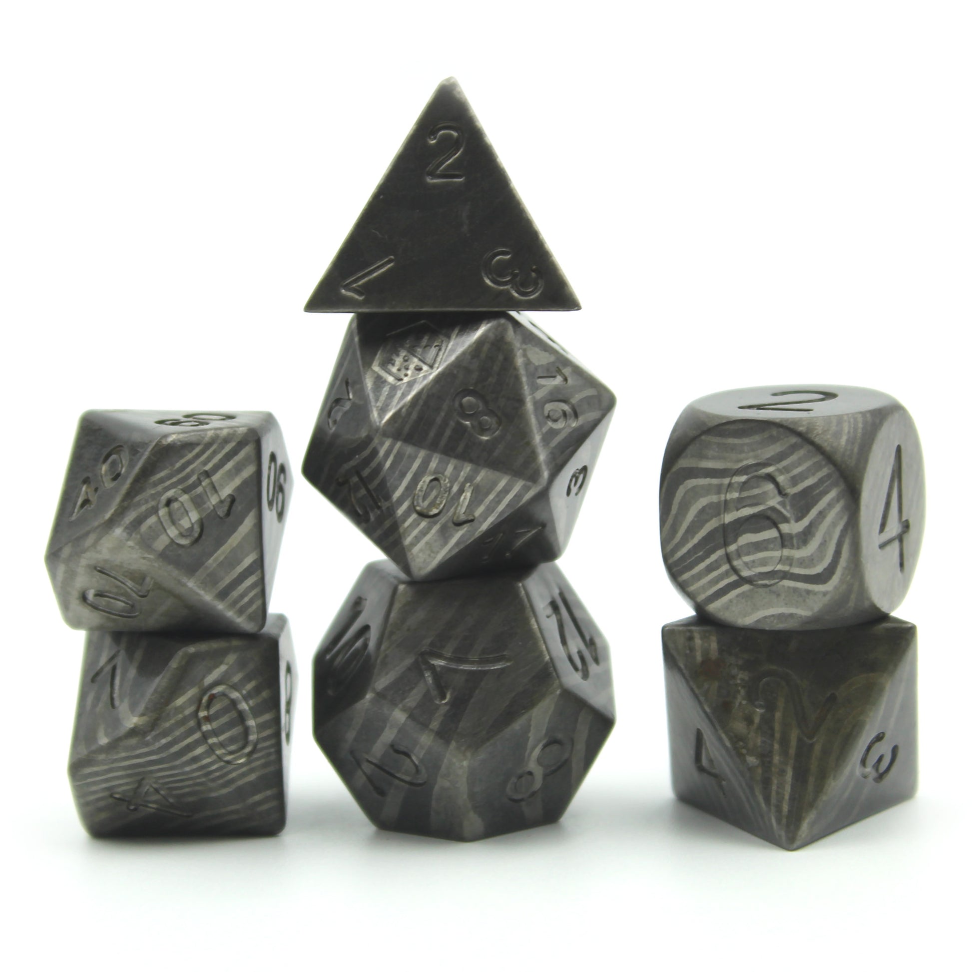 Metal Damascus Steel dice set arranged in 3 columns on a white surface and background.