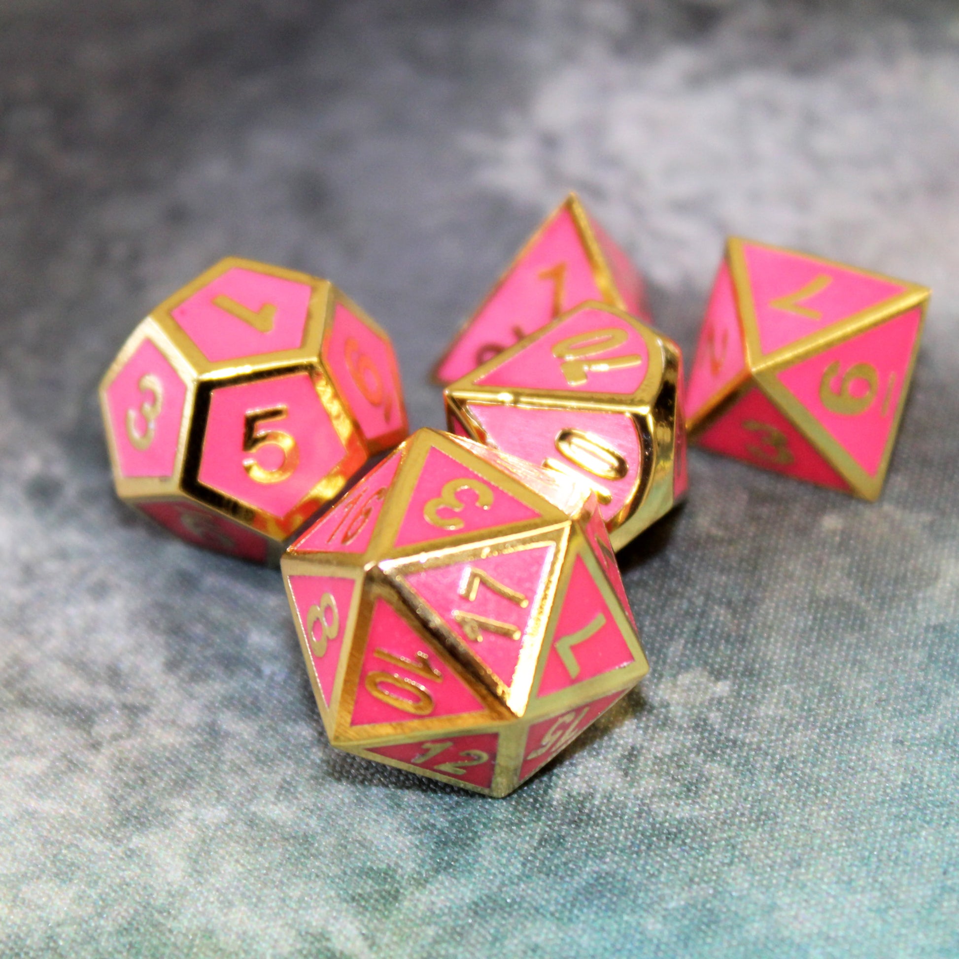Five of the imperial pink dice set scattered on a gray printed map surface.
