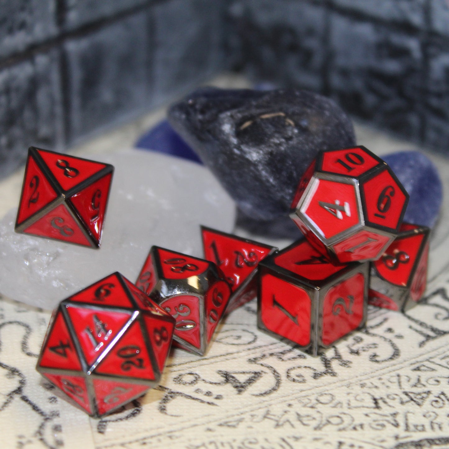 Imperial Red dice set scattered on top of a tan play mat with a stone wall set piece behind them.