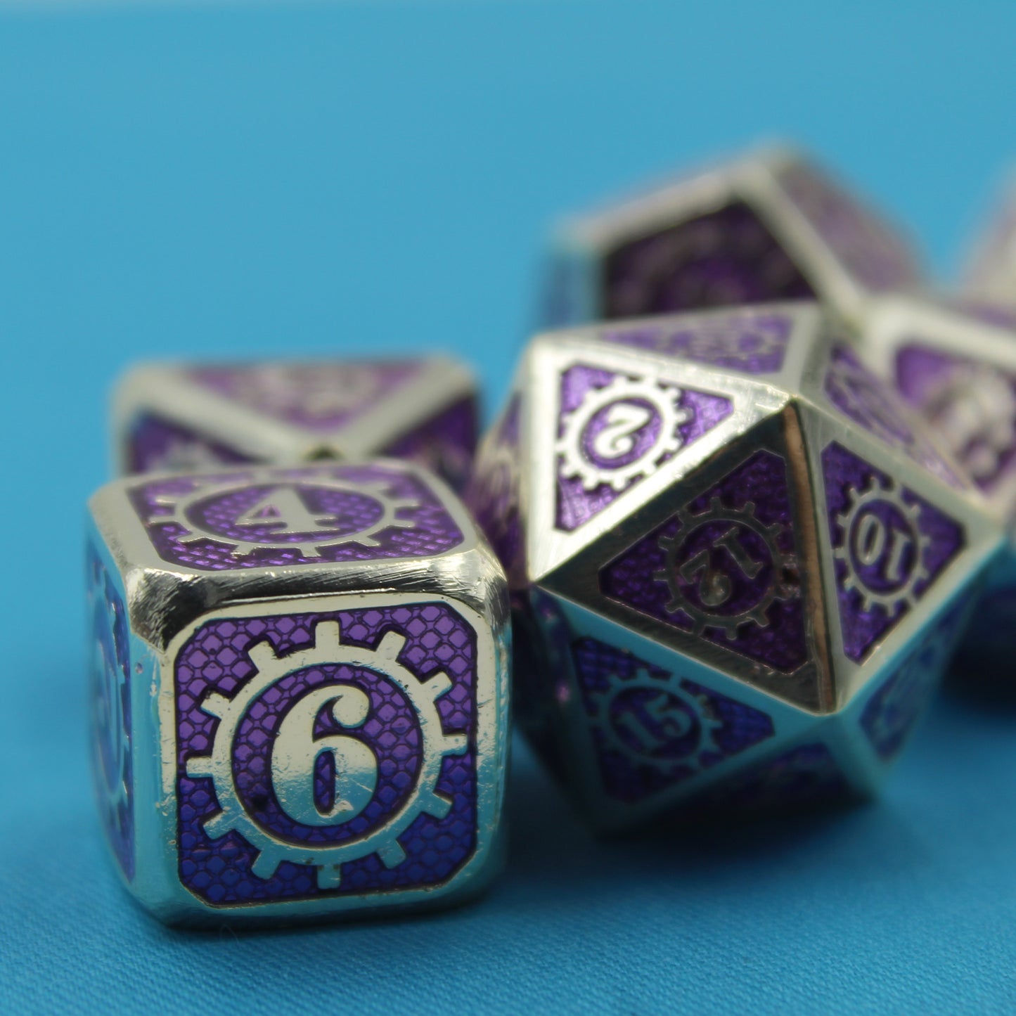 A closeup of the D6 and D20 dice in the Mechanist set on top of a blue cloth.