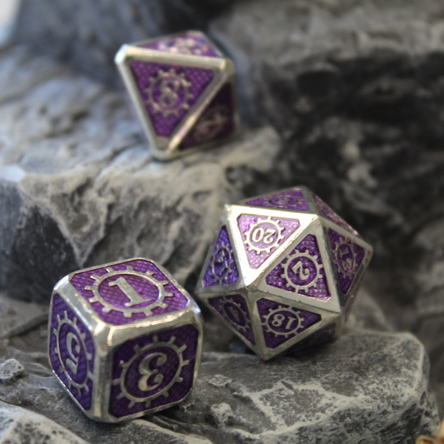 Three dice in the Mechanist set arranged on a rocky set piece.