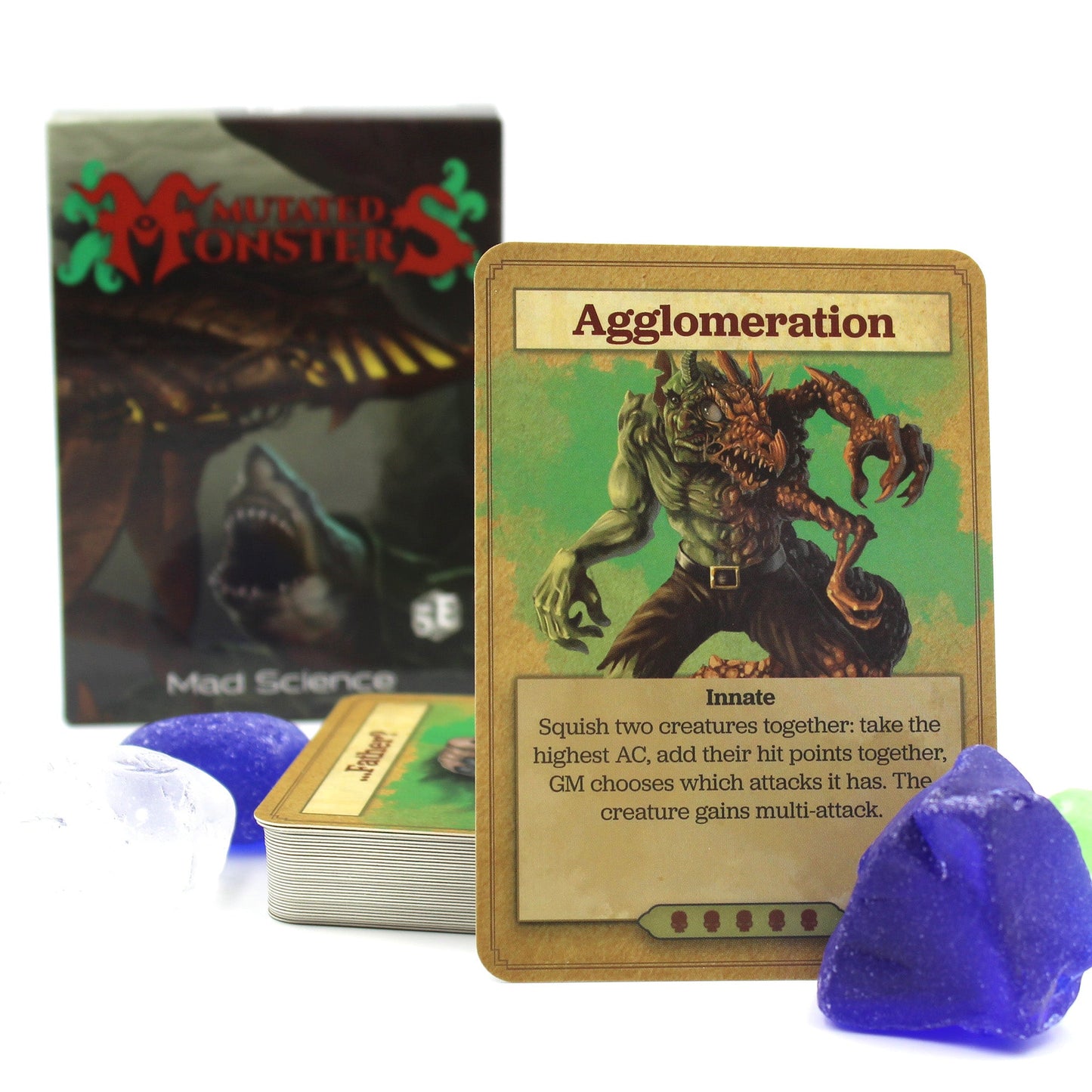 The deck box in the background with a stack of cards in the midground and a card propped up in the foreground. Cards are surrounded by a few blue and white stones. All on a white background.