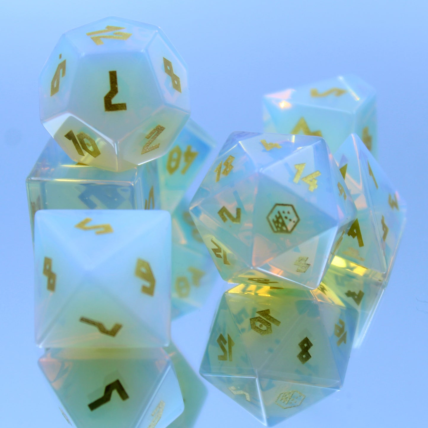 Opalite dice set displayed on a mirror, revealing shifting hues of blue, green, orange, and pink, perfect for Dungeons and Dragons.