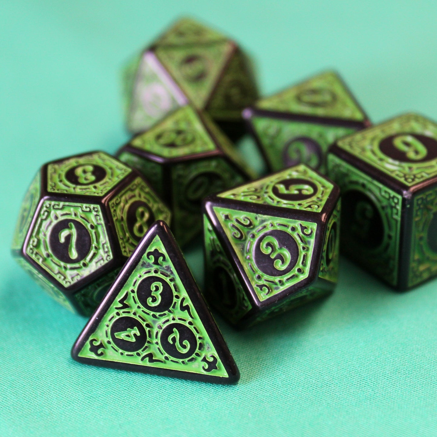 Oracle's Flame green dice set arranged on a teal cloth.