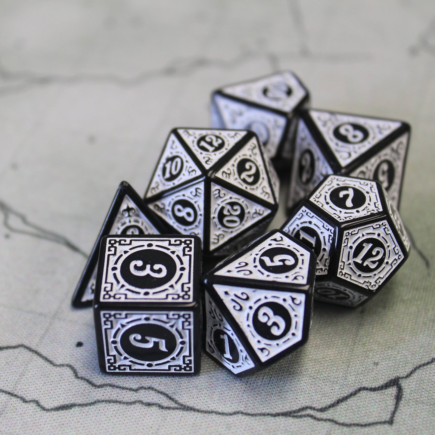 Oracle's Flame white dice set arranged in a pile on top of a white game map.