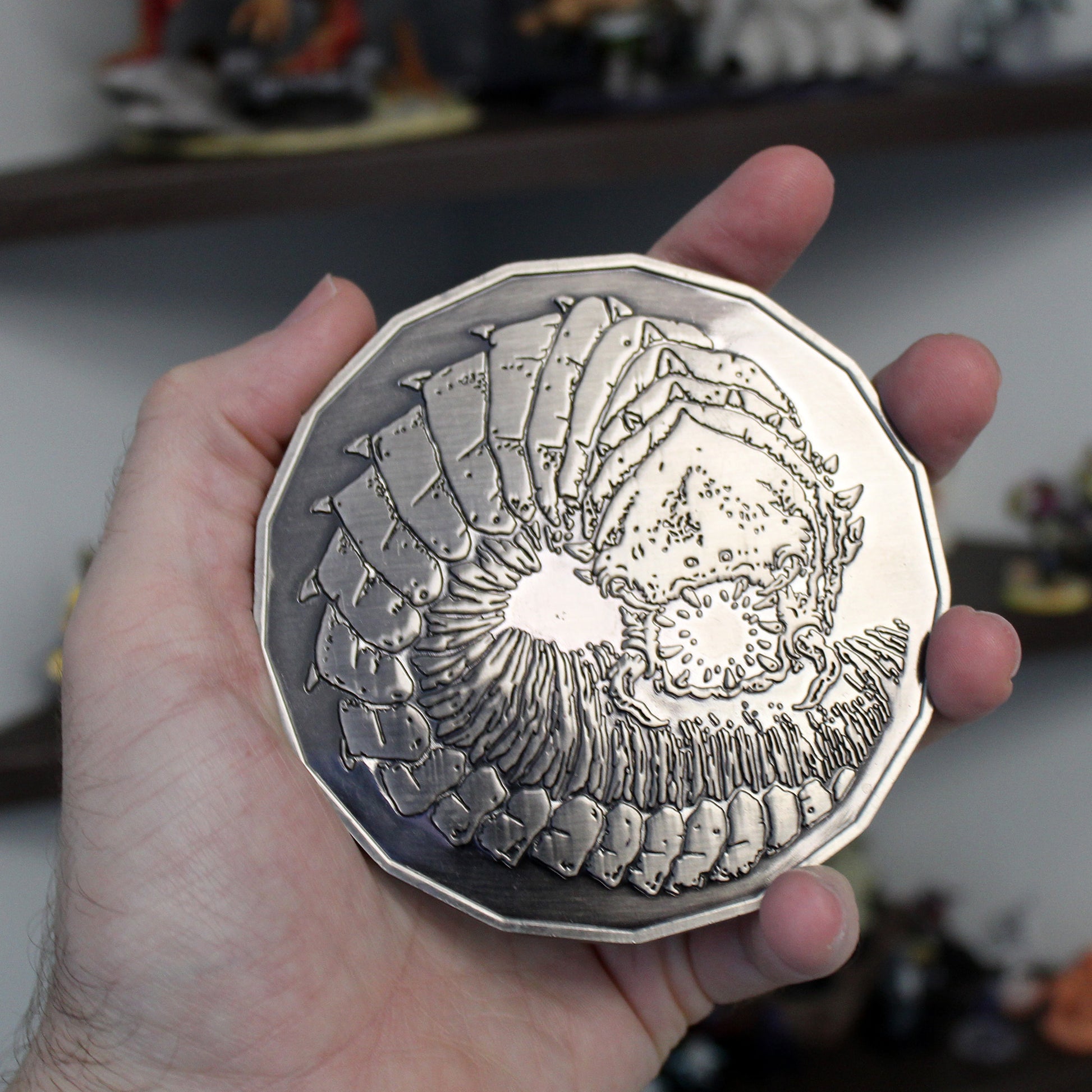 Purple Worm monster token held in hand, highlighting its large 4-inch diameter and weight, perfect for representing the fearsome creature in RPG gameplay.