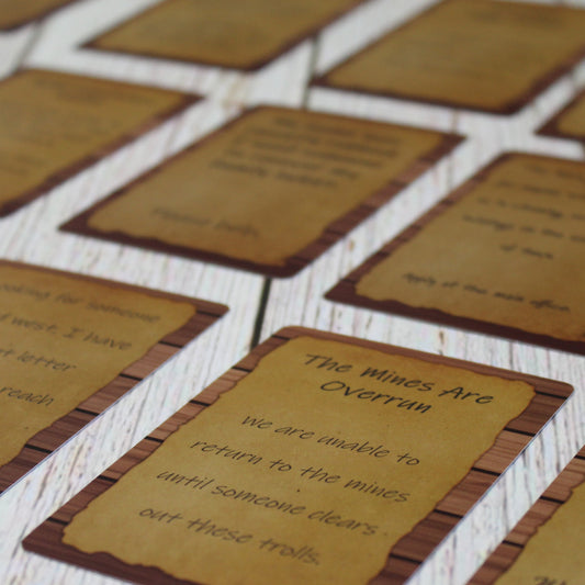 Array of Quest Deck: The Notice Board cards spread out on a table, displaying various quest prompts for use in tabletop RPG campaigns.