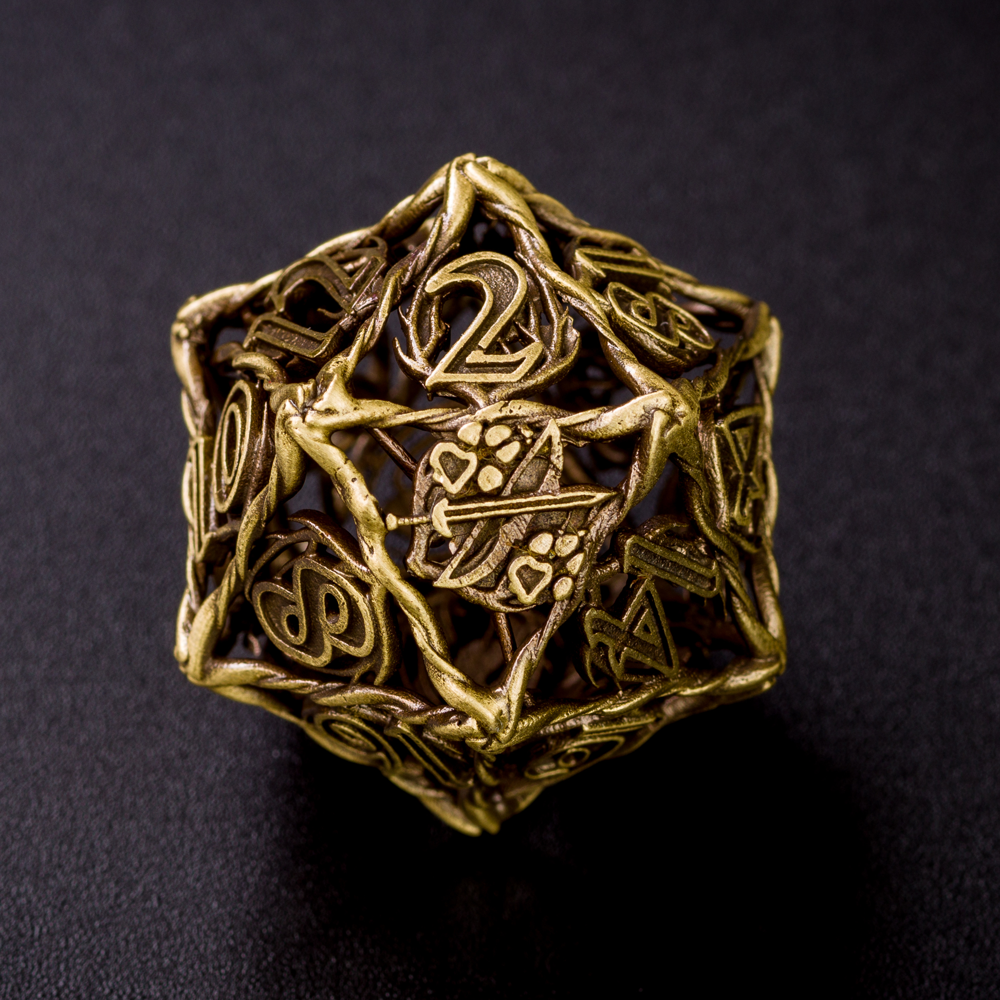 Close up of a Bronze Ranger D20 on a black surface. The dice is turned to the 20 side, showing the 20 has been replaced with the ranger logo - a sword with a paw print on its left and right side.