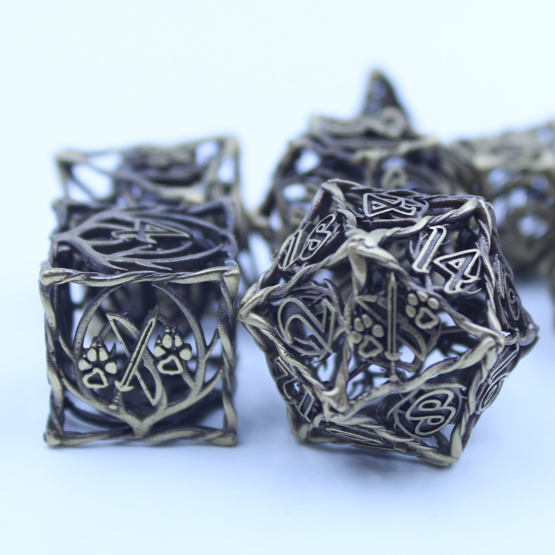 Close up of the D20 and D6 dice on a white surface and background, both turned to the side showcasing the ranger logo - a sword with a paw print on its left and right side.