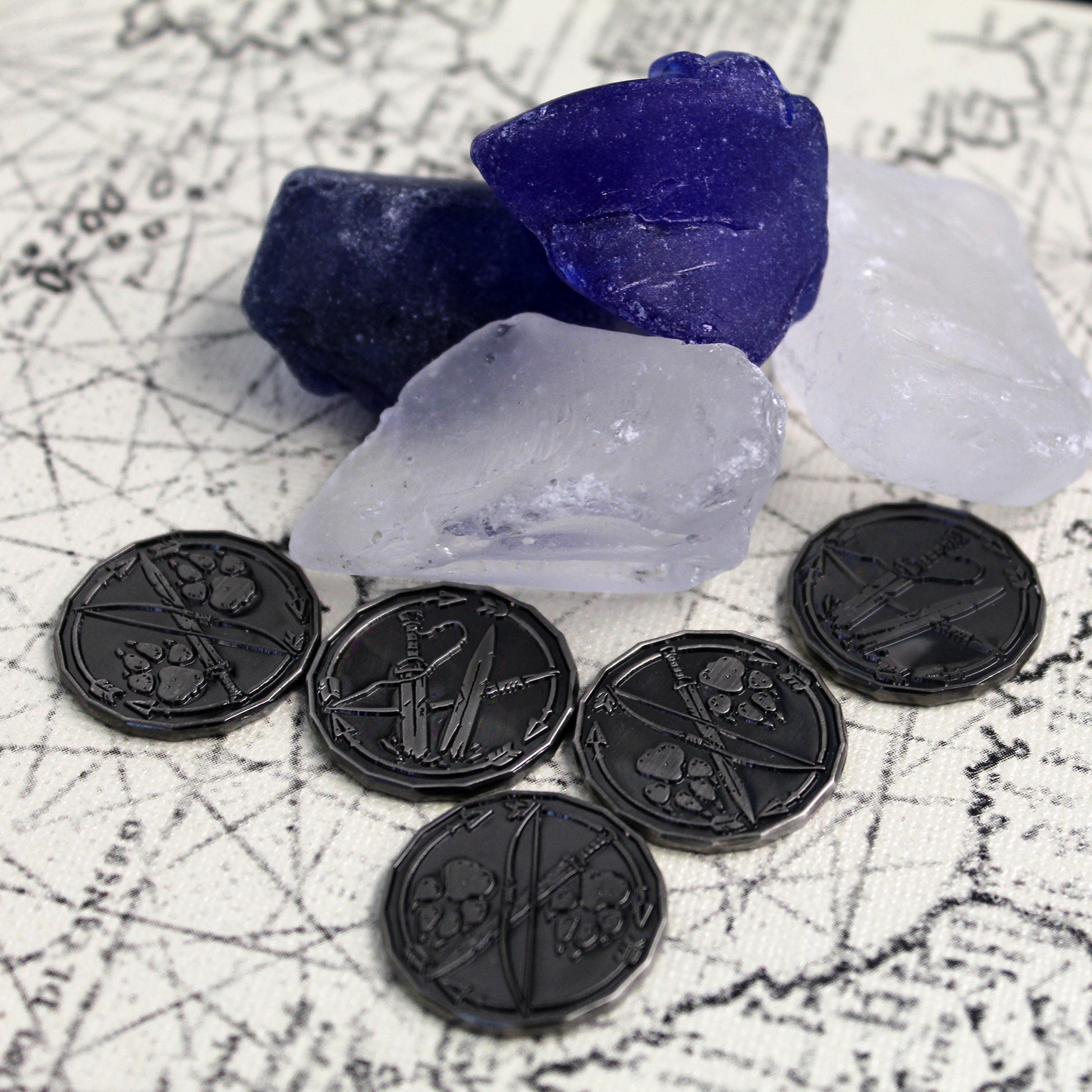Five silver ranger character tokens sitting on a map next to dark blue and cloudy white glass chunks