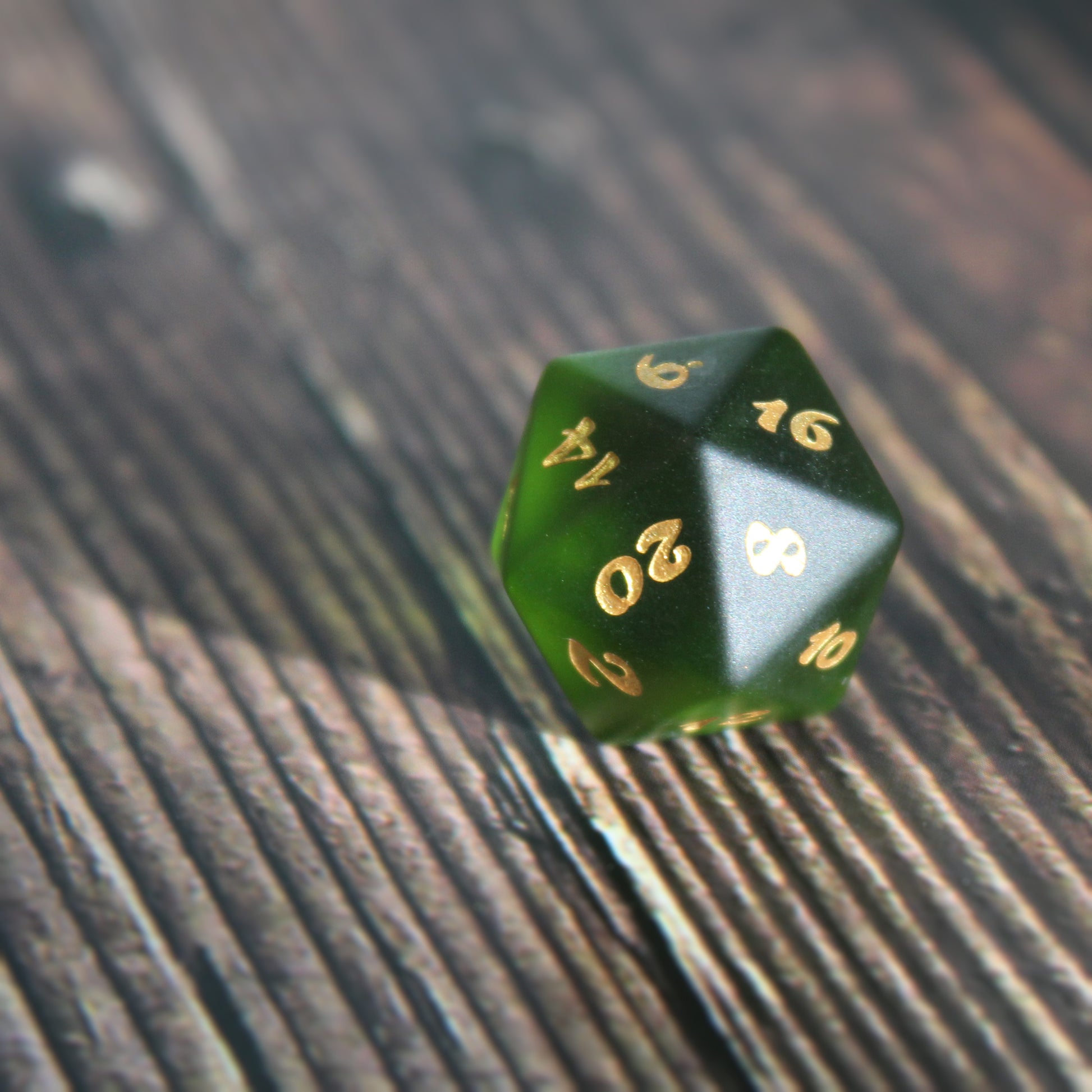 D20 alone on a wooden table, highlighting its frosted glass texture and ocean-themed engravings.