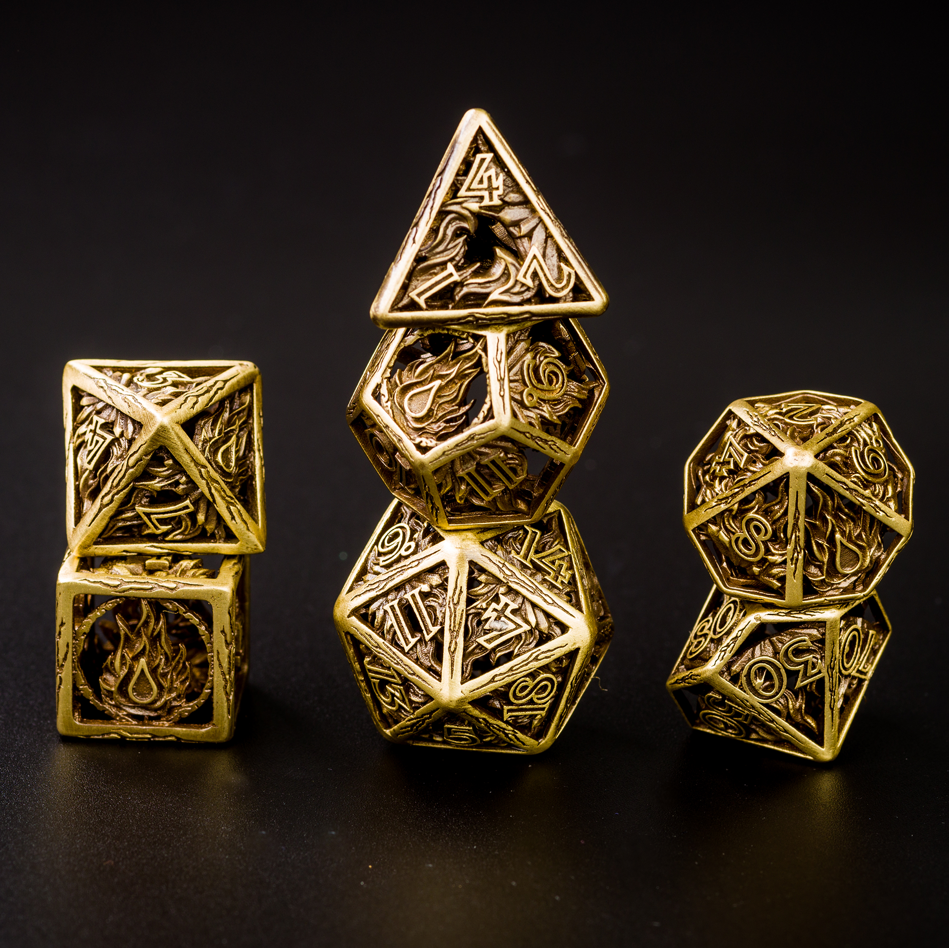 All 7 brass dice piled up in 3 stacks. Two dice in first stack, three dice in second stack, two dice in third stack. All on a black background.