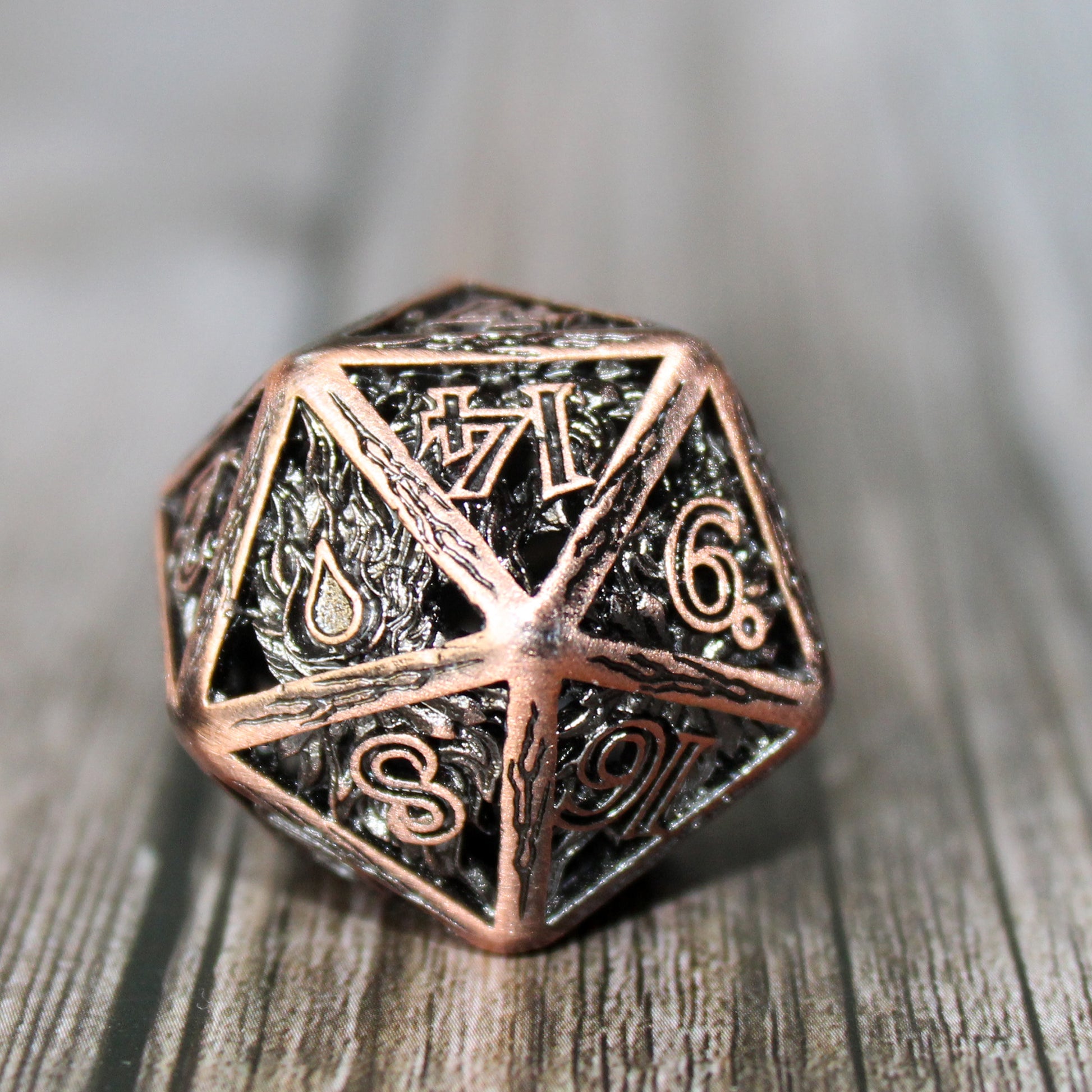 Copper 20 sided die on a wooden paneled surface