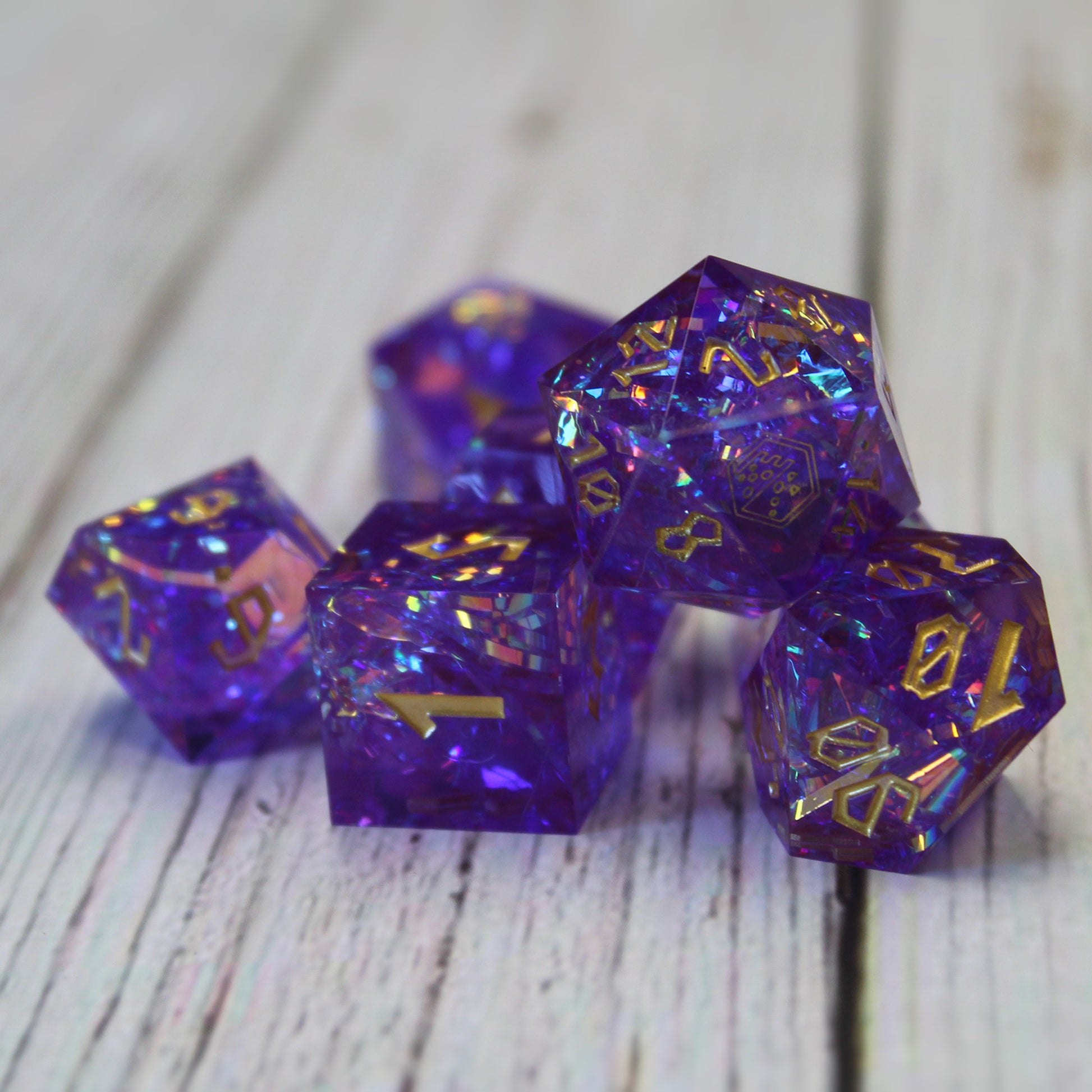 StarGlow Purple dice set arranged in a pile on a white wood surface.