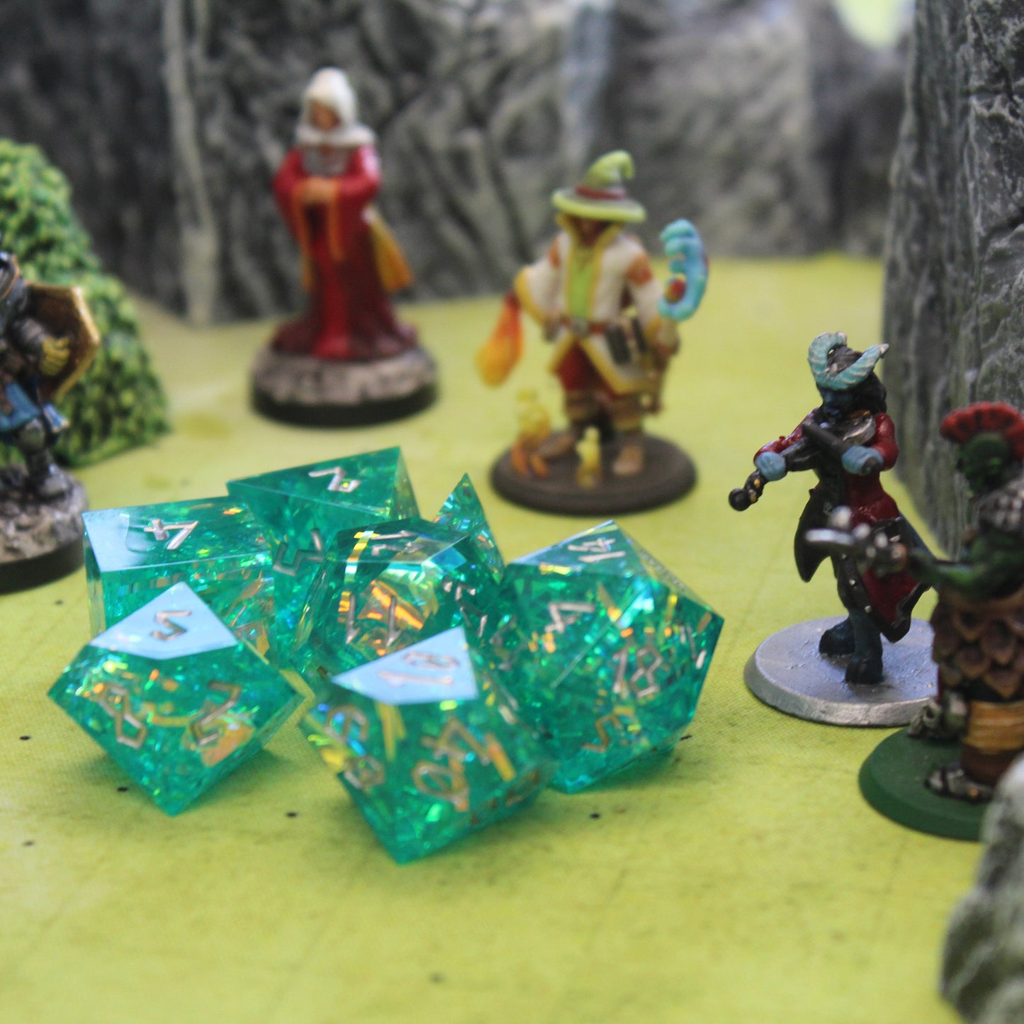 StarGlow Turquoise resin dice set on a table with Dungeons & Dragons miniatures, designed for RPG gameplay.