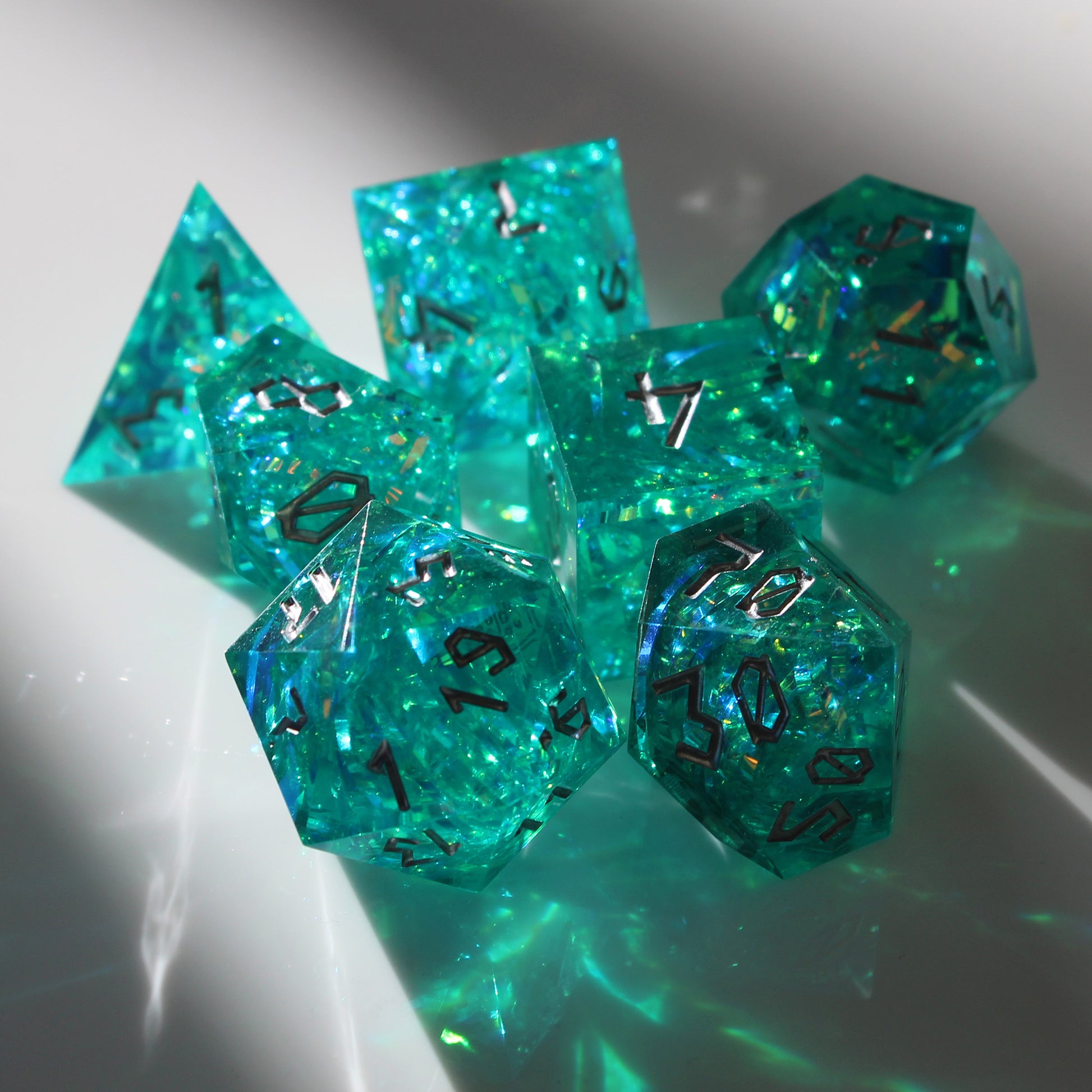StarGlow Turquoise dice set under light, revealing vibrant colors and glowing iridescent inclusions in translucent resin.