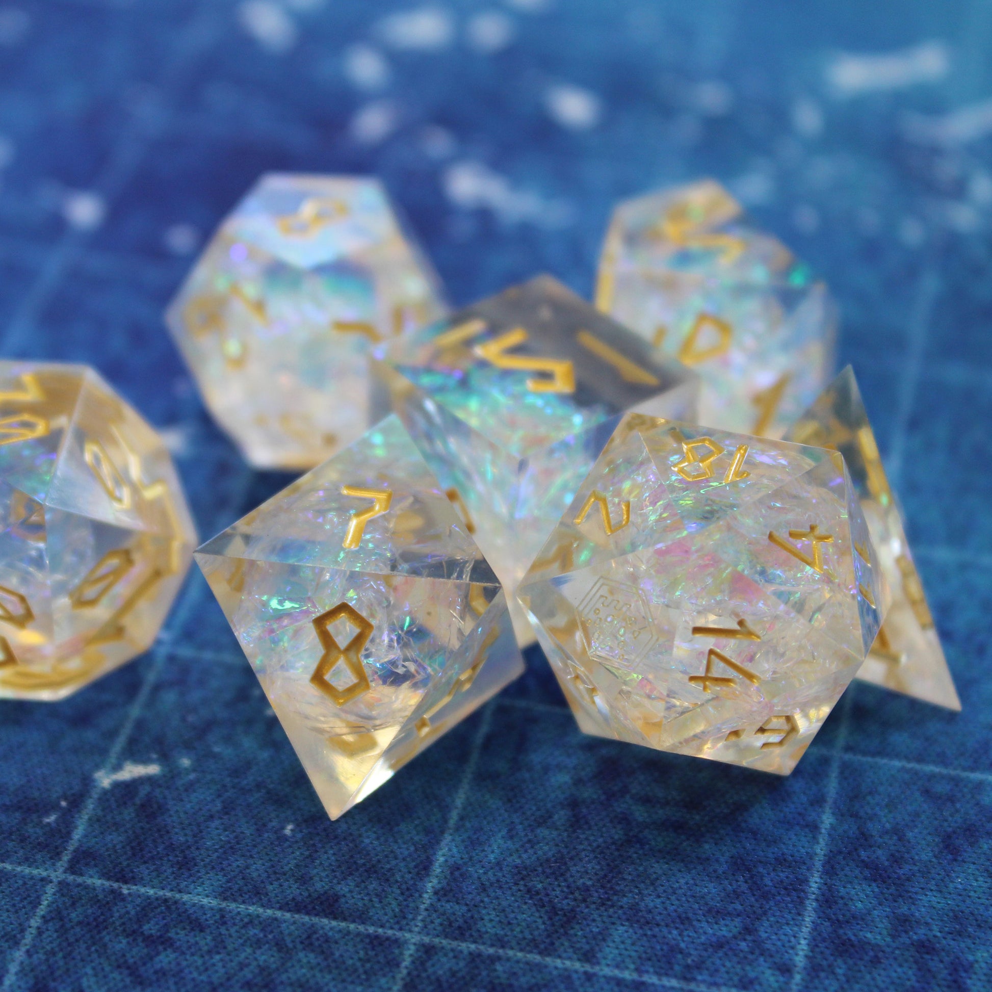 StarGlow White dice set arranged in a pile on a blue game mat.