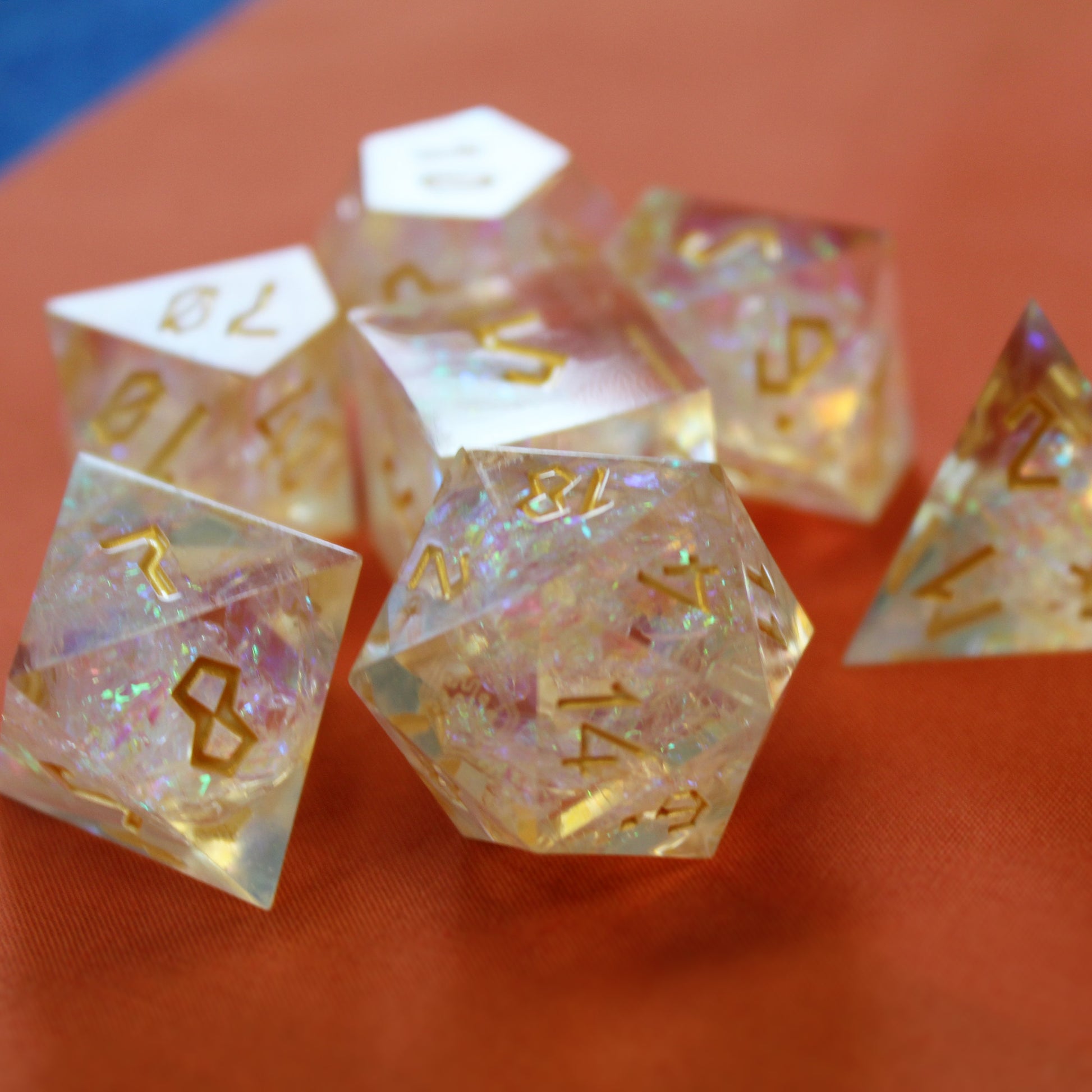 StarGlow White dice set arranged in a pile on an orange surface.