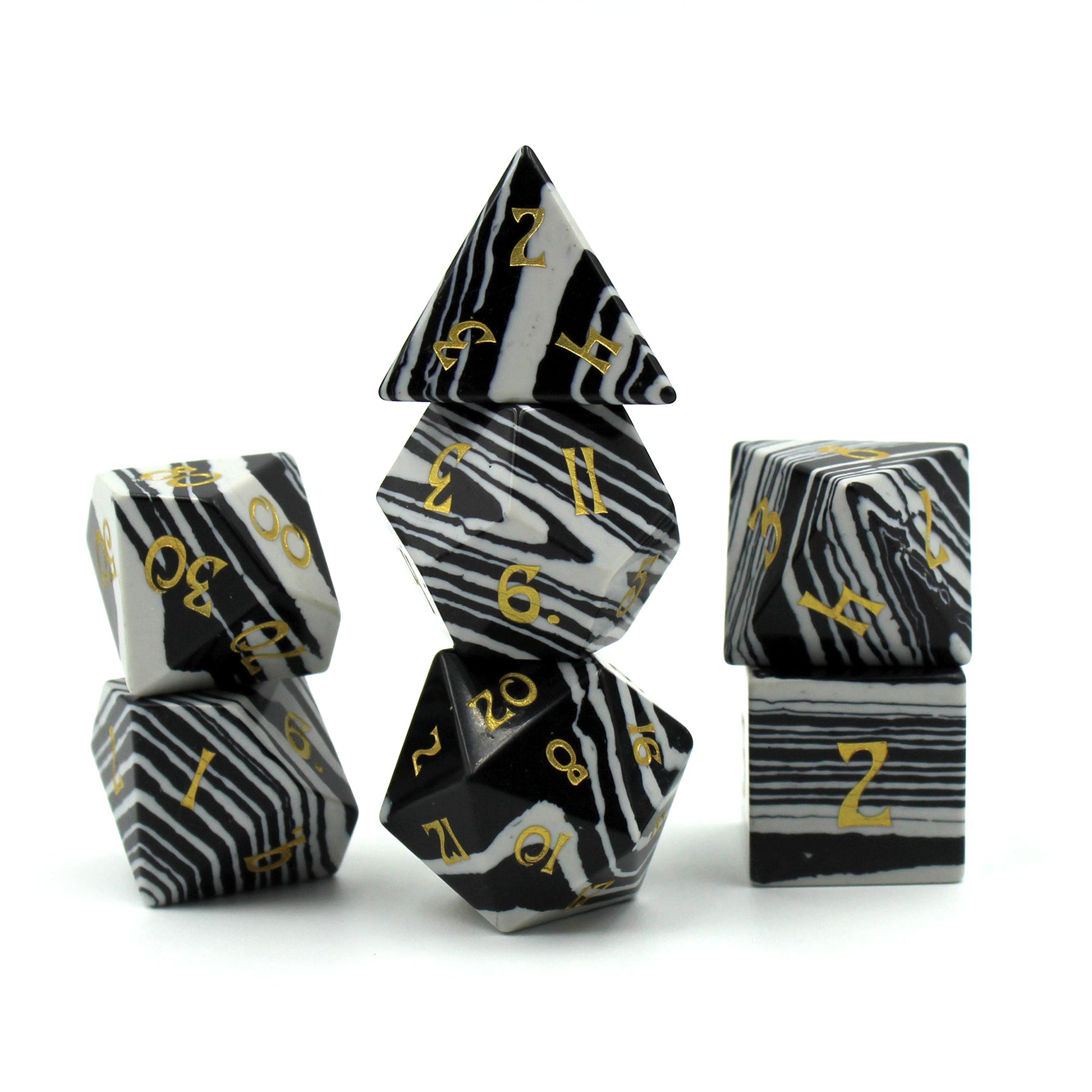 Stacked Set of Black and White Striped Dice with Gold Numbering on a White Background