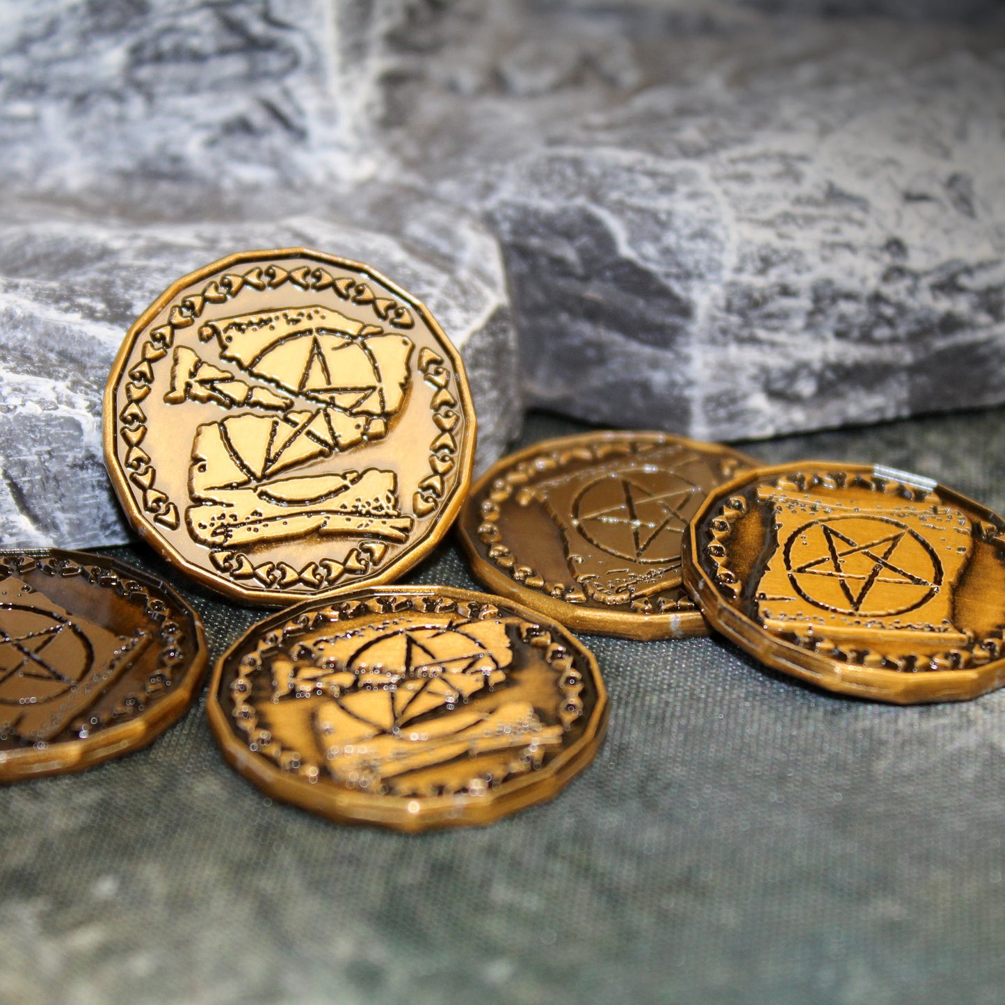 Five golden Warlock tokens on a rock background
