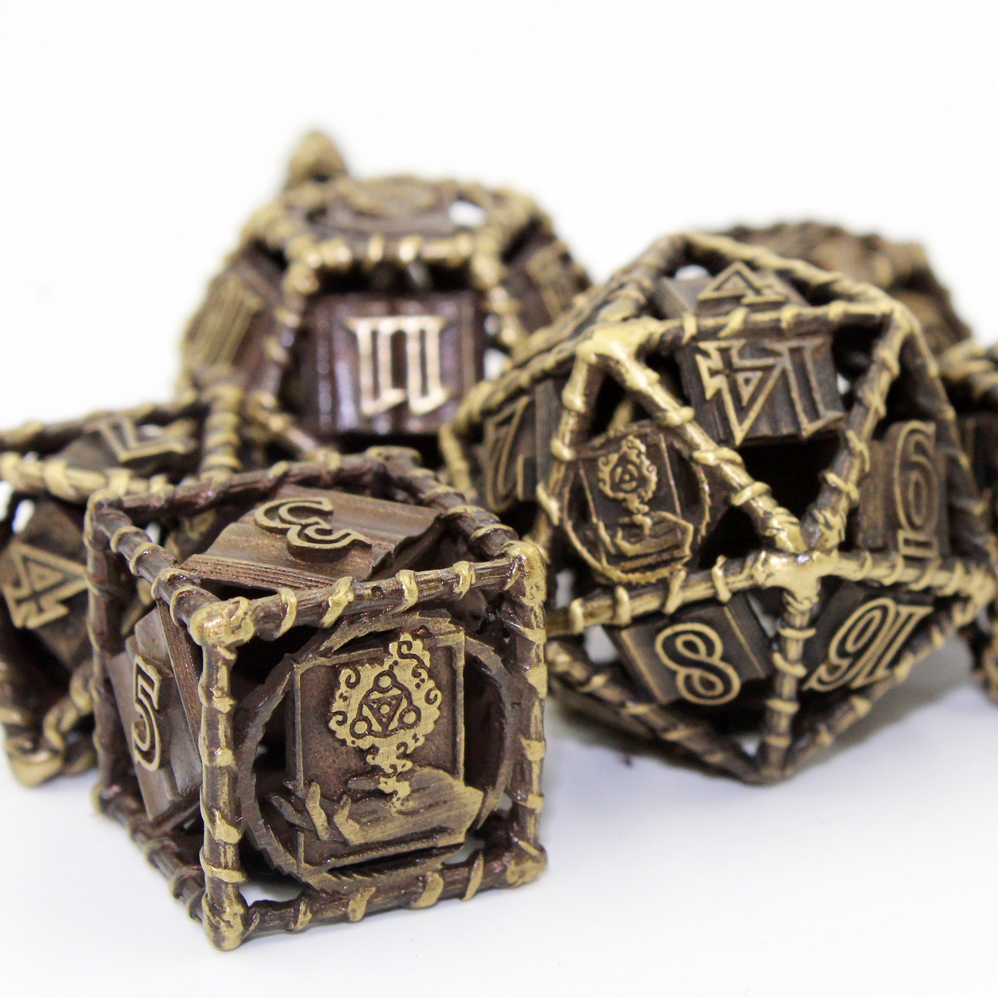 bronze 20 sided die and 6 sided die on foreground, with other dice in set blurred in background. All on a white background.