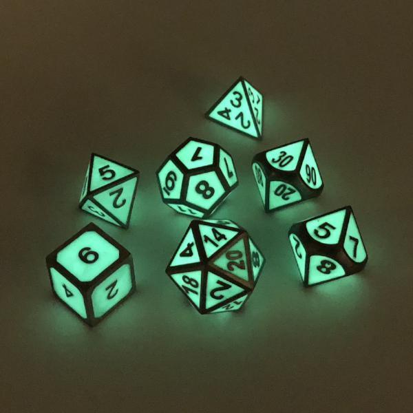 Metal Imperial Glow in the Dark dice set scattered in the dark, showcasing the glowing green color