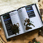 Open book showing dungeons and dragons monsters statistics with figurines on a map