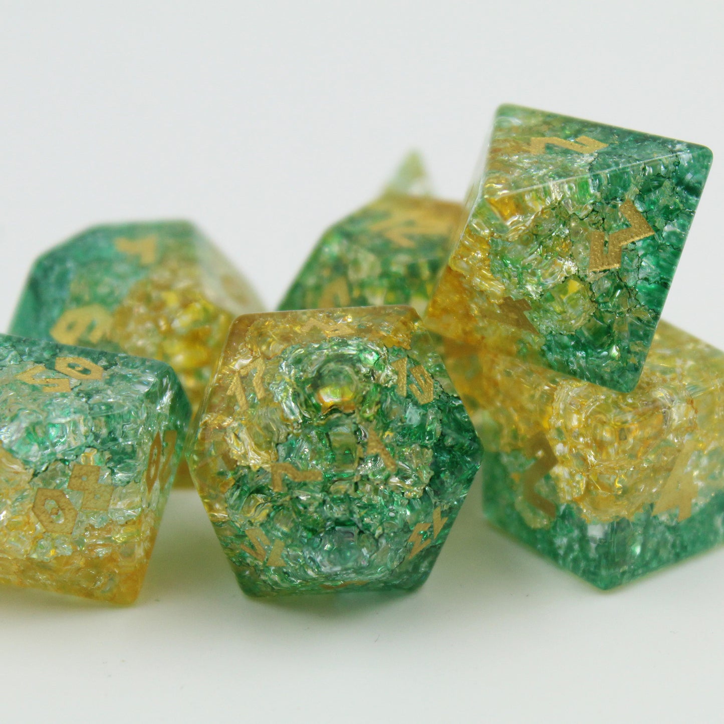 green and yellow glass dice grouped on a white background, reflecting light uniquely for RPG enthusiasts.