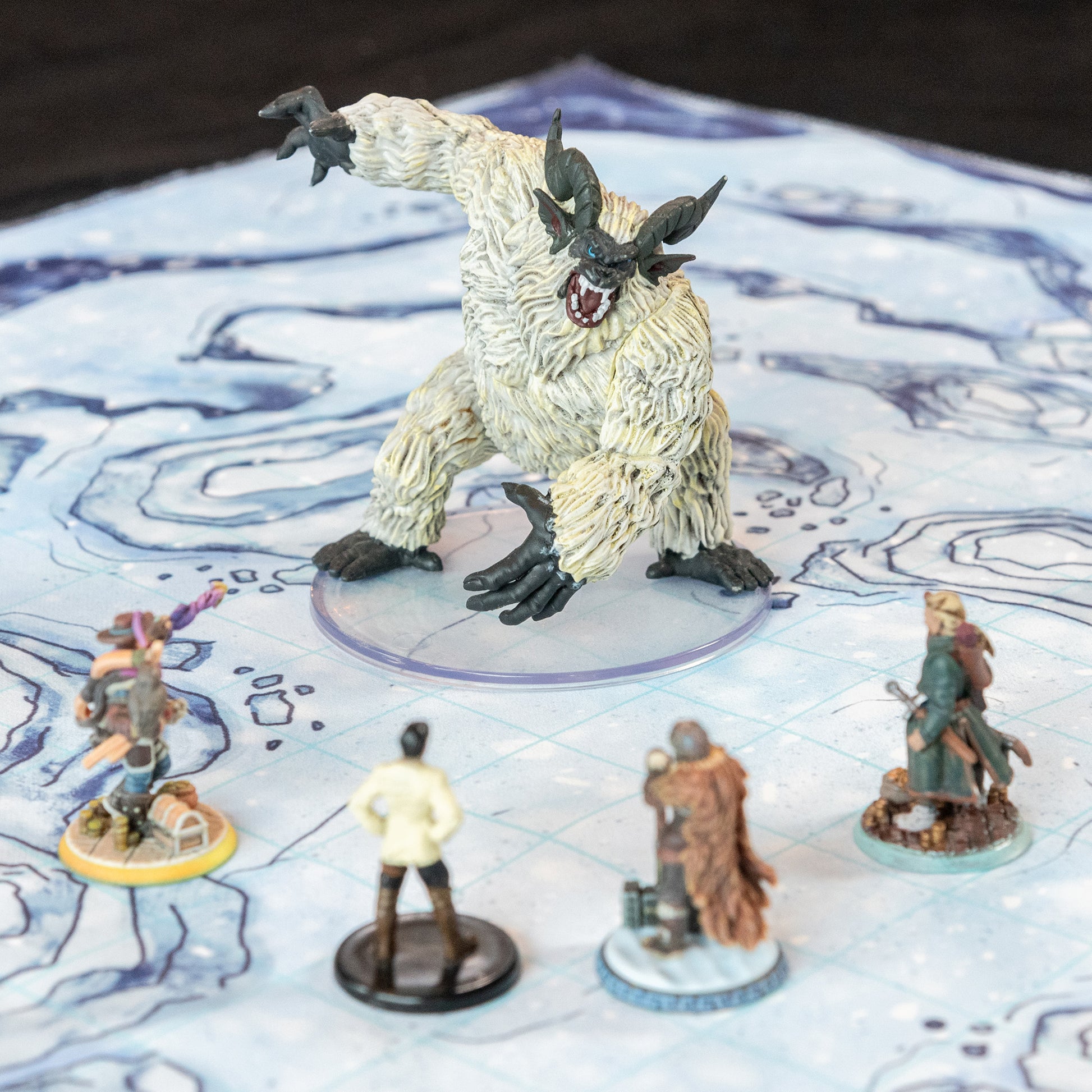 Closeup photo of a snowy battle map with various miniature figures on it