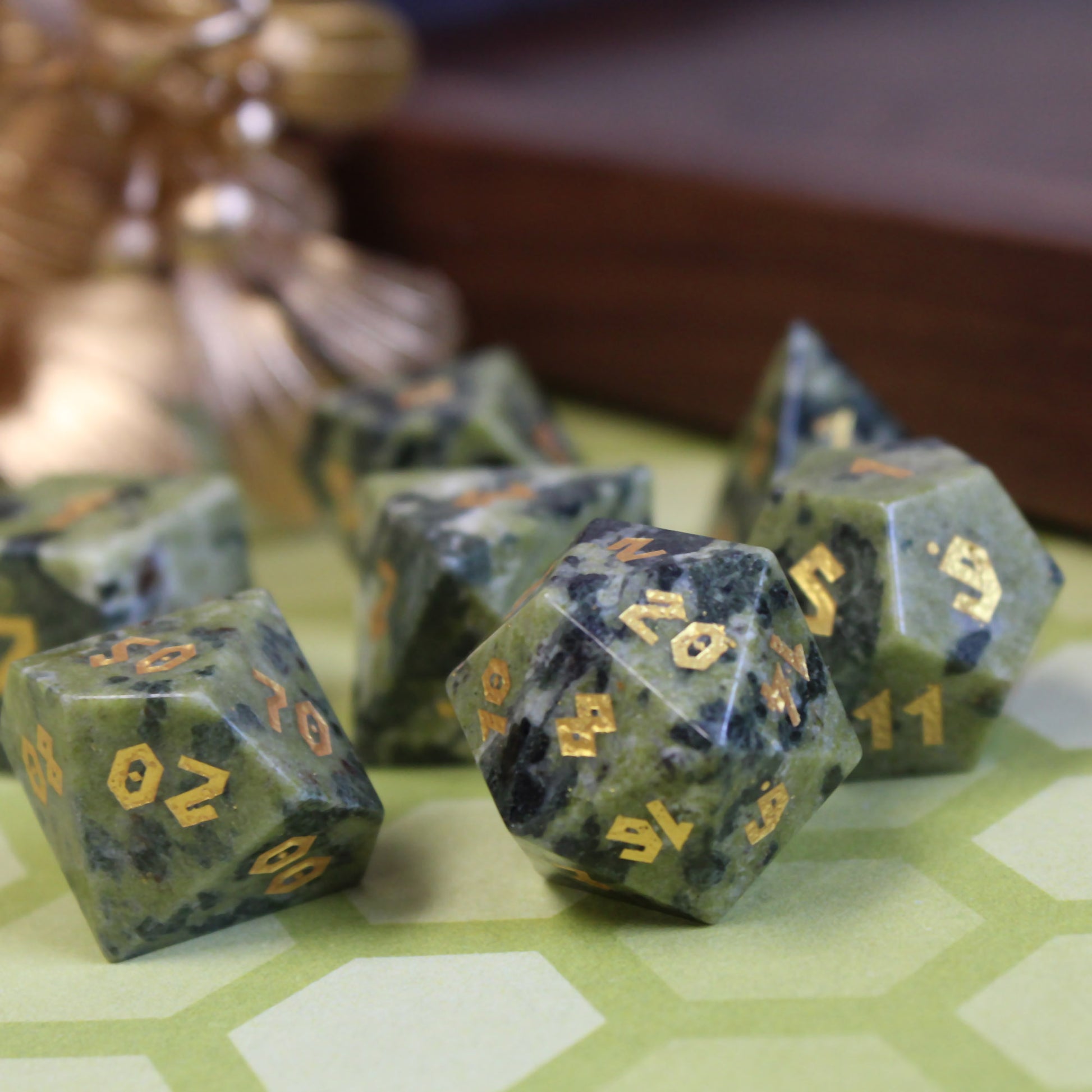 Full Brazilian Jade dice set displayed, featuring Greko-Roman style font inked in gold on finely crafted 16mm jade dice.