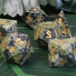 Detailed close-up of the Brazilian Jade dice set, focusing on the gold ink used for the numbers.